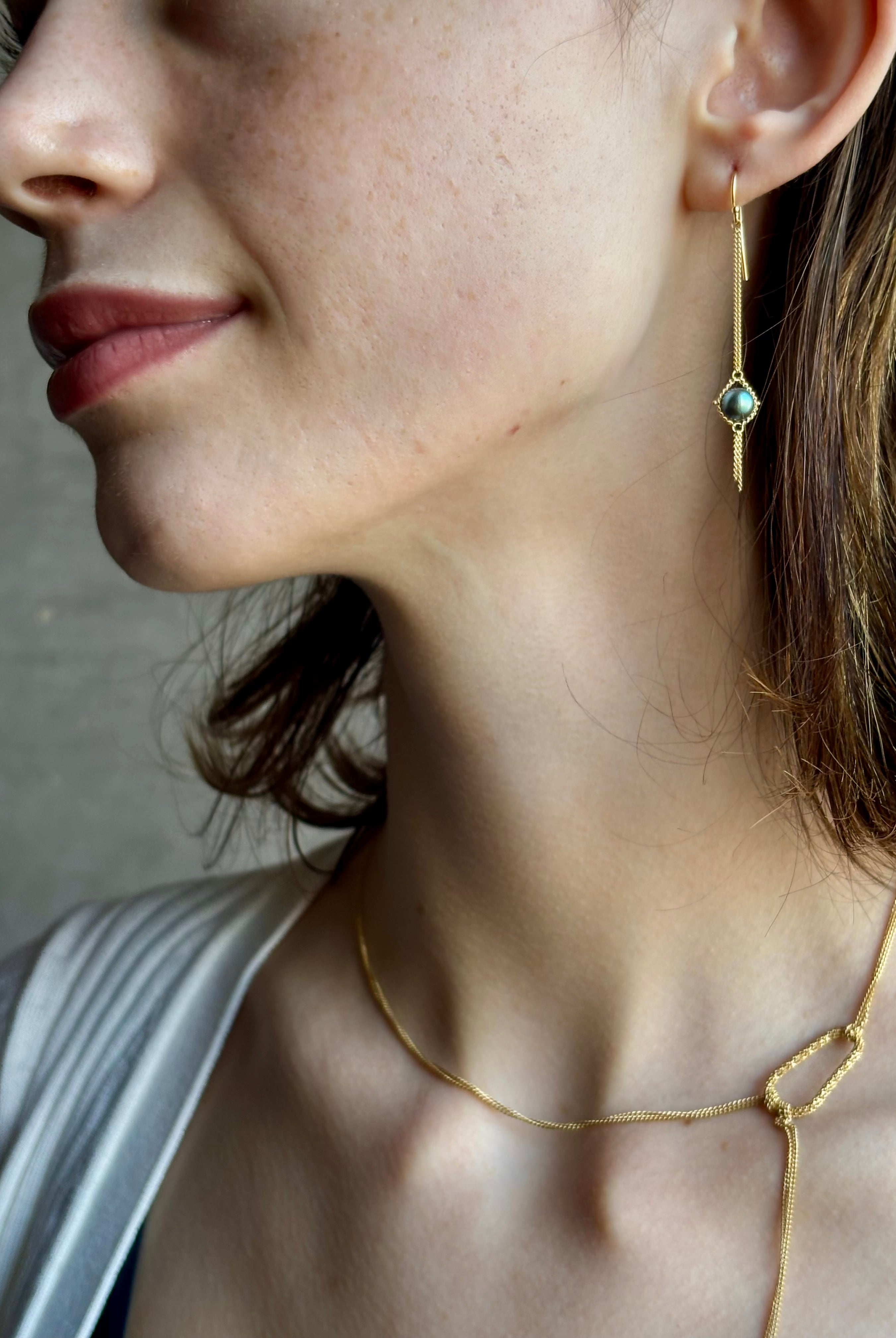 Woman wearing refined fine jewelry with iridescent blue Akoya pearls in an elegantly wearable drop silhouette in 18k yellow gold from New york designer Amali with kinetic fun fringe bottom detail