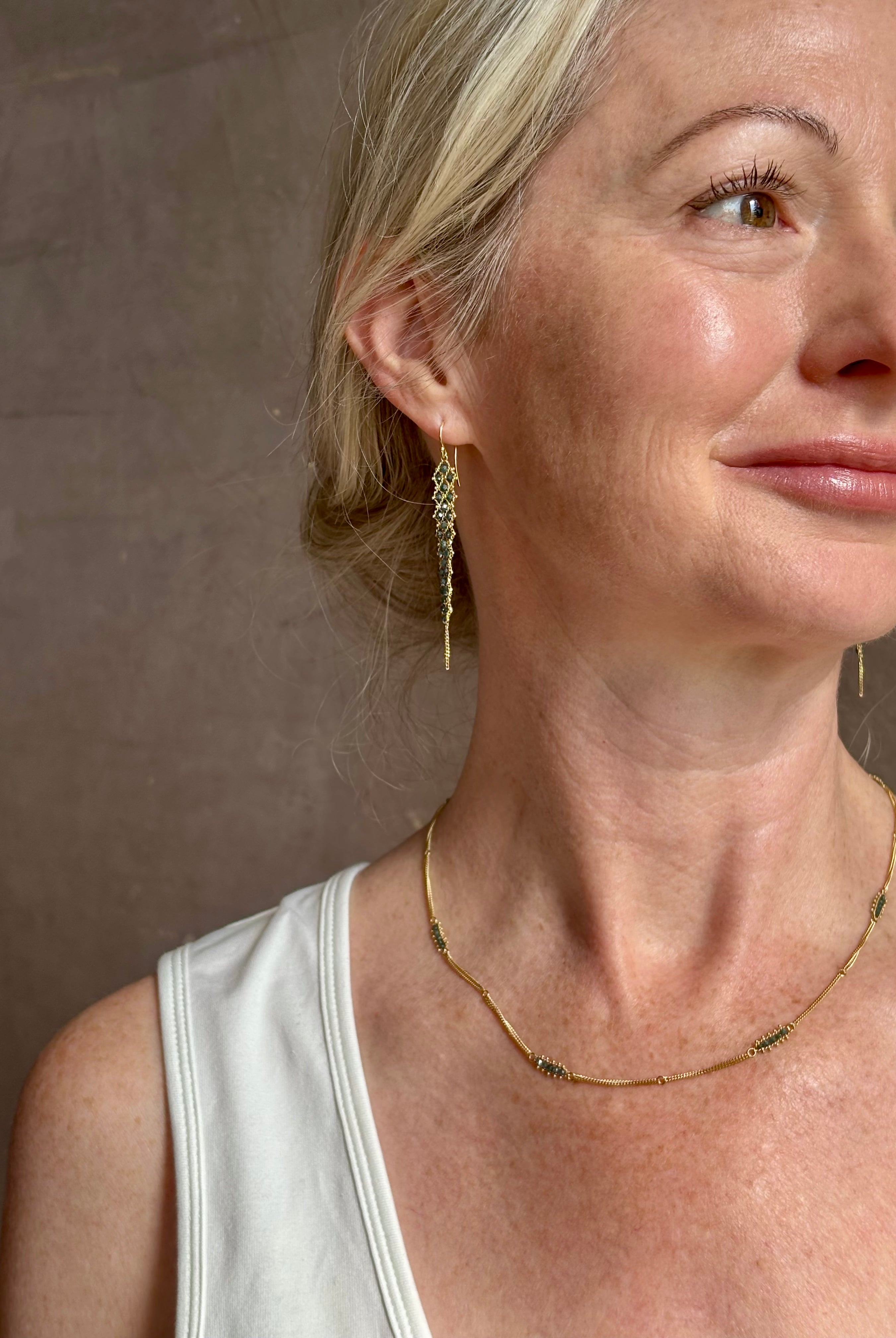 Mature woman wearing a double layered chain natural blue diamond necklace from fine jewelry designer Amali handcrafted in Chapel Hill North Carolina in warm 18K yellow gold