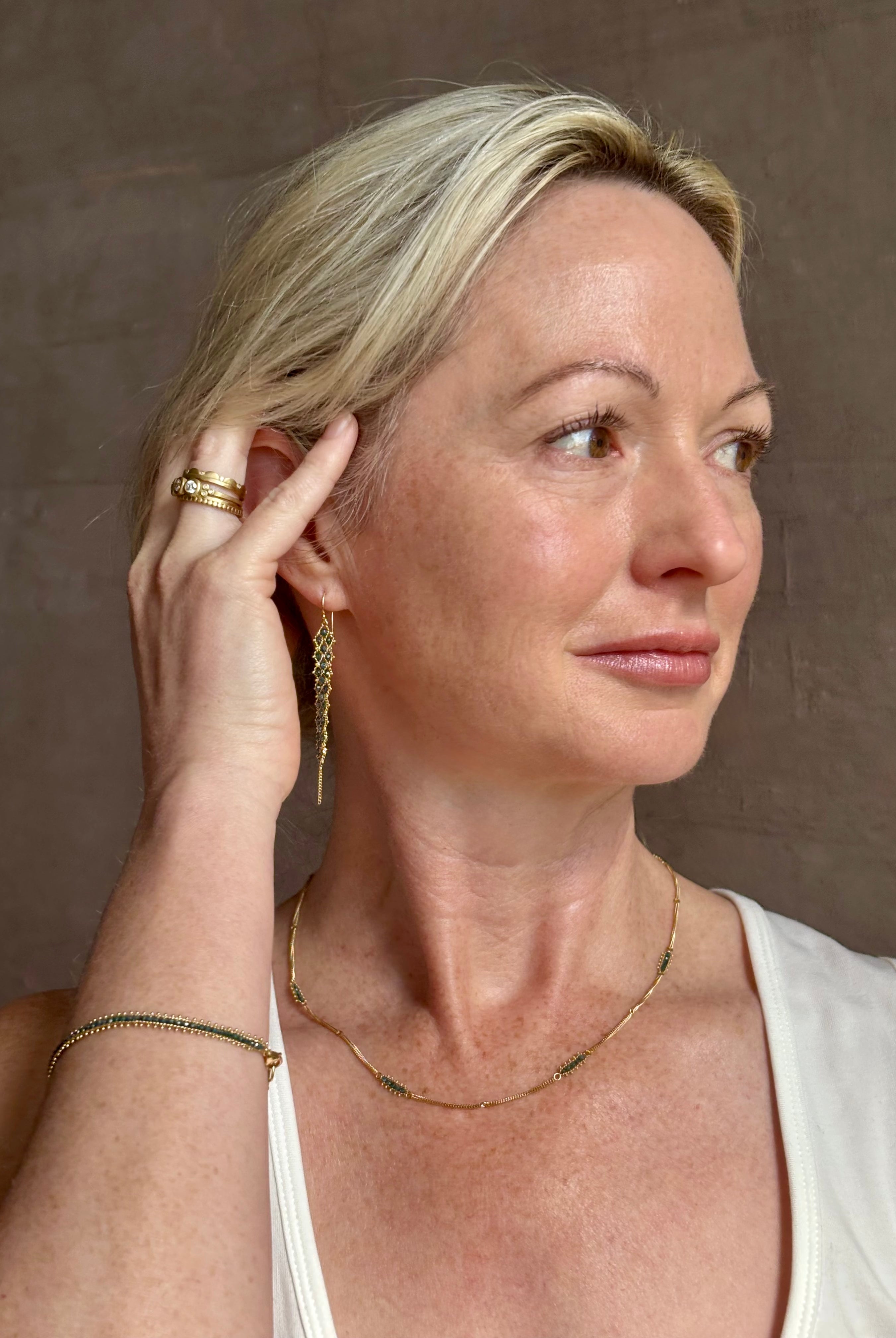 Mature woman wearing a double layered chain natural blue diamond necklace from fine jewelry designer Amali handcrafted in Chapel Hill North Carolina in warm 18K yellow gold