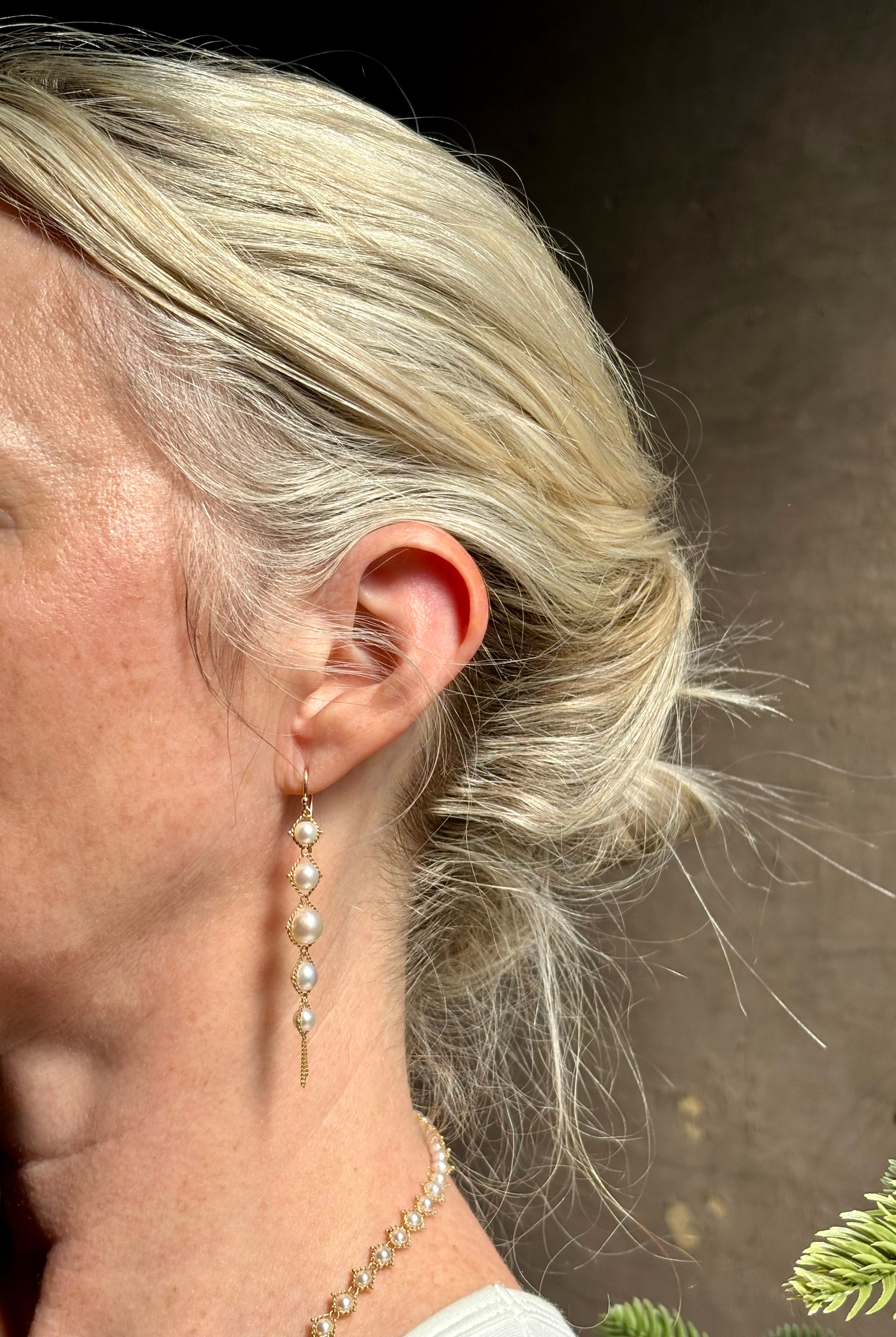 Image of graduated Akoya Pearl Drop Earrings from North Carolina fine jewelry artist Amali with each lustrous white Akoya pearl individually suspended in hand-woven lengths of delicate 18K yellow gold chain and french wire hooks