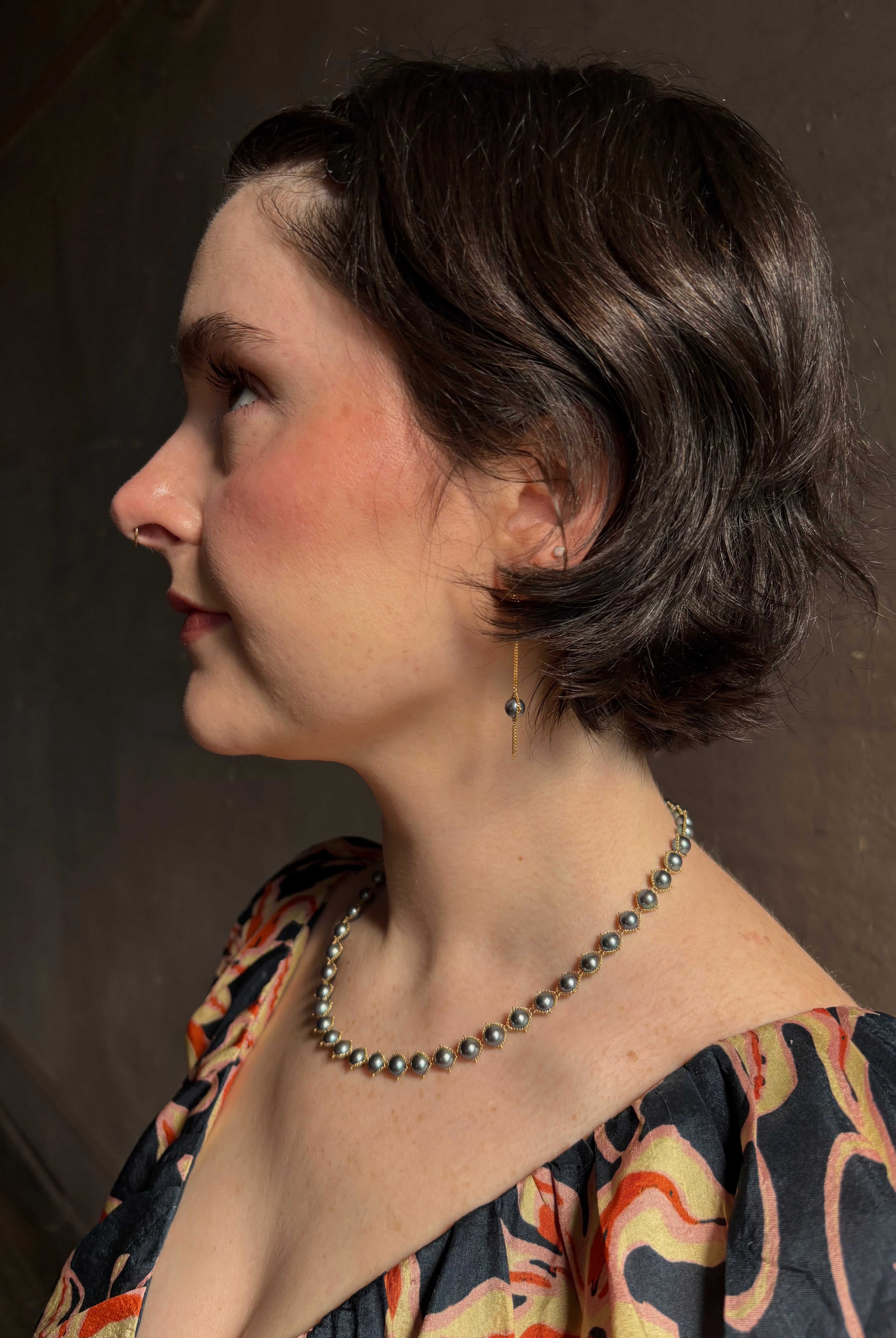 Woman wearing luxury Grey Akoya Pearl Necklace from fine jewelry artist Amali handcrafted in New York in warm 18K yellow gold with matching earrings