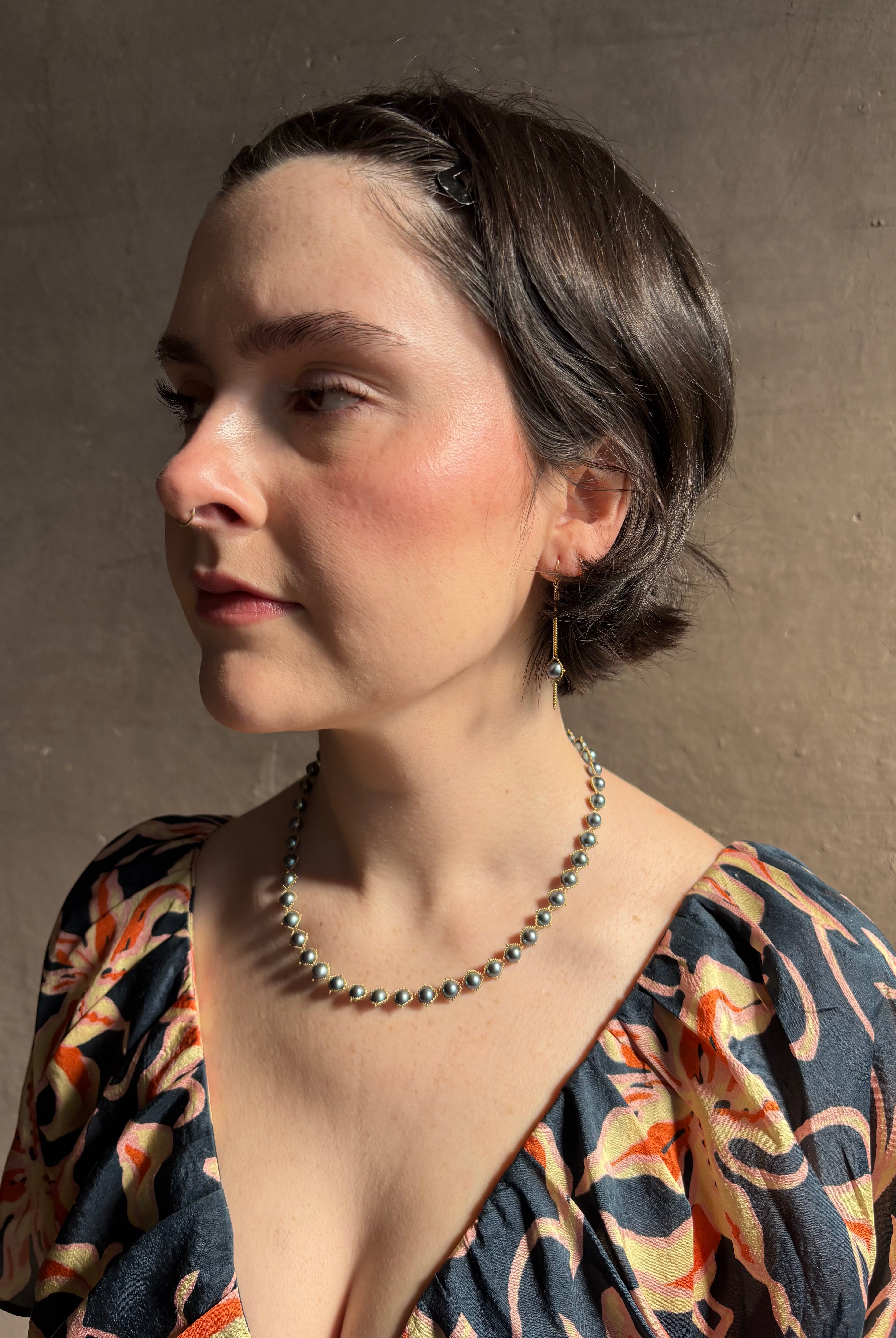 Woman wearing luxury Grey Akoya Pearl Necklace from fine jewelry artist Amali handcrafted in New York in warm 18K yellow gold with matching earrings