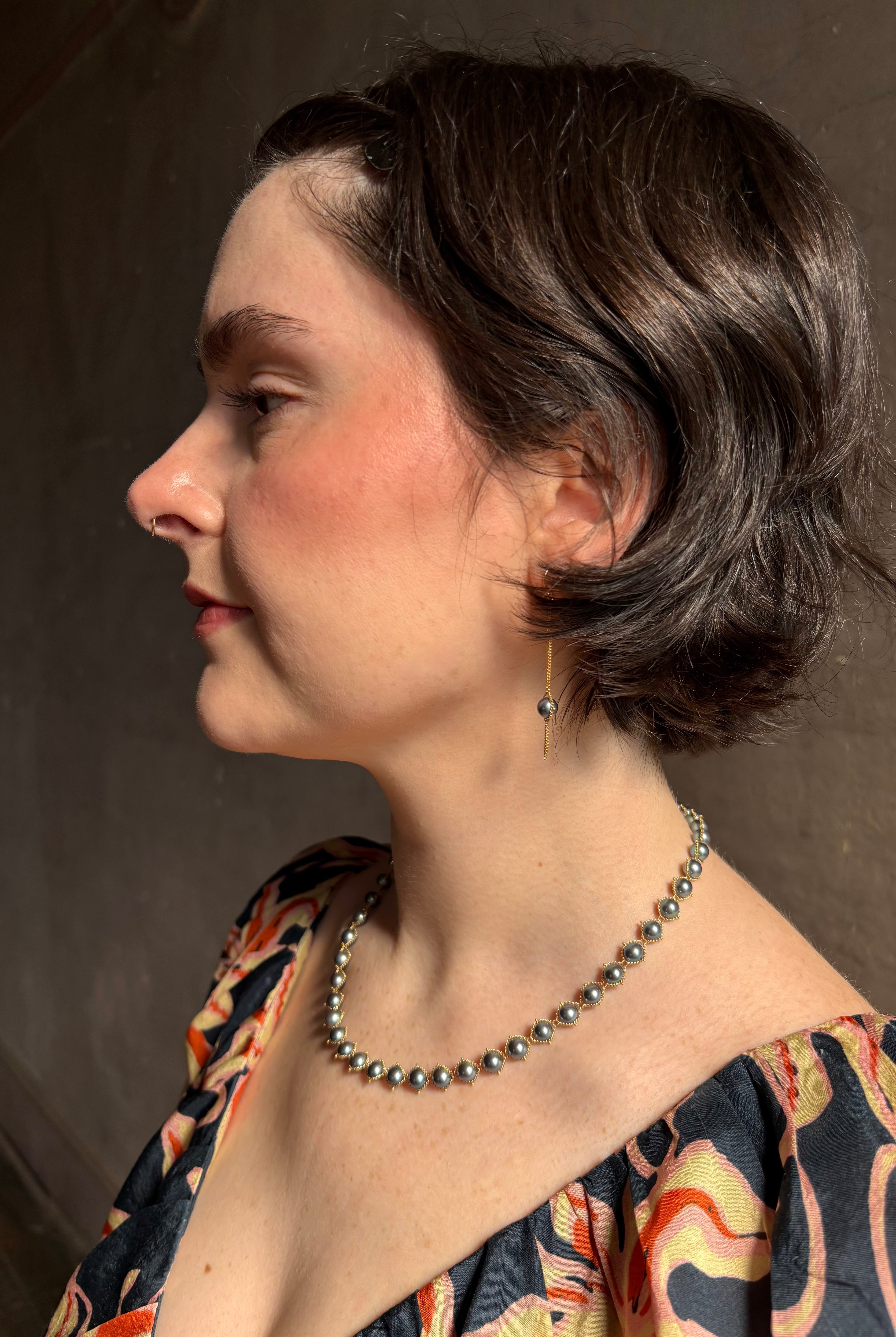 Woman wearing luxury Grey Akoya Pearl Necklace from fine jewelry artist Amali handcrafted in New York in warm 18K yellow gold with matching earrings