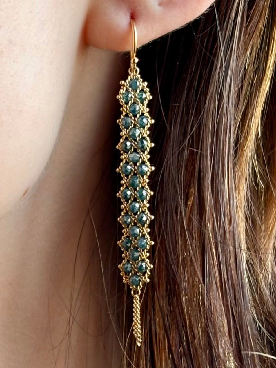 Woman wearing hand woven blue diamonds and 18k yellow gold earrings by New York jewelry designer Amali