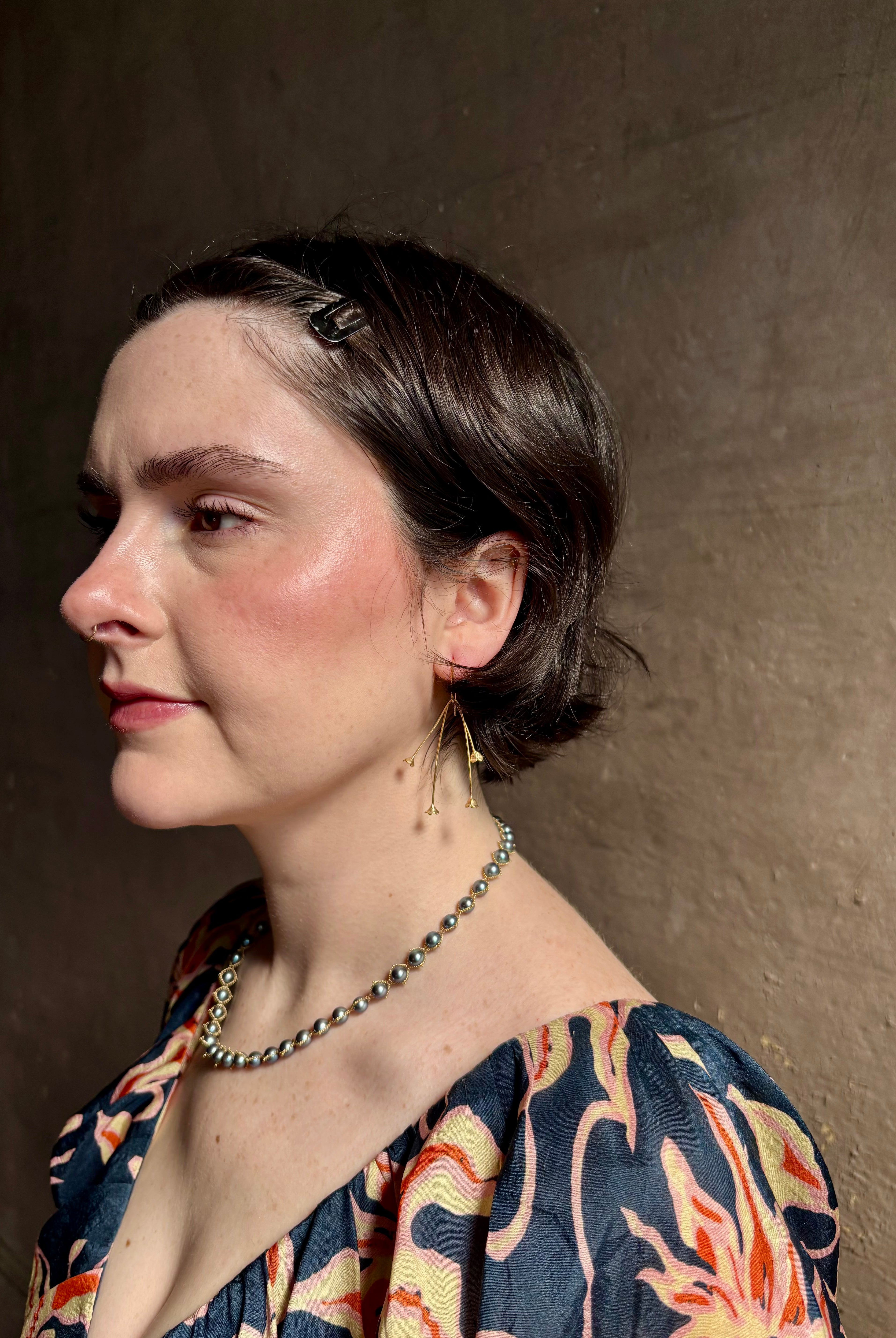 Woman wearing Lily of the Valley Earrings from North Carolna fine jewelry artist Amber Mahler handcrafted 18K yellow gold vermeil with four dangling flower blossoms