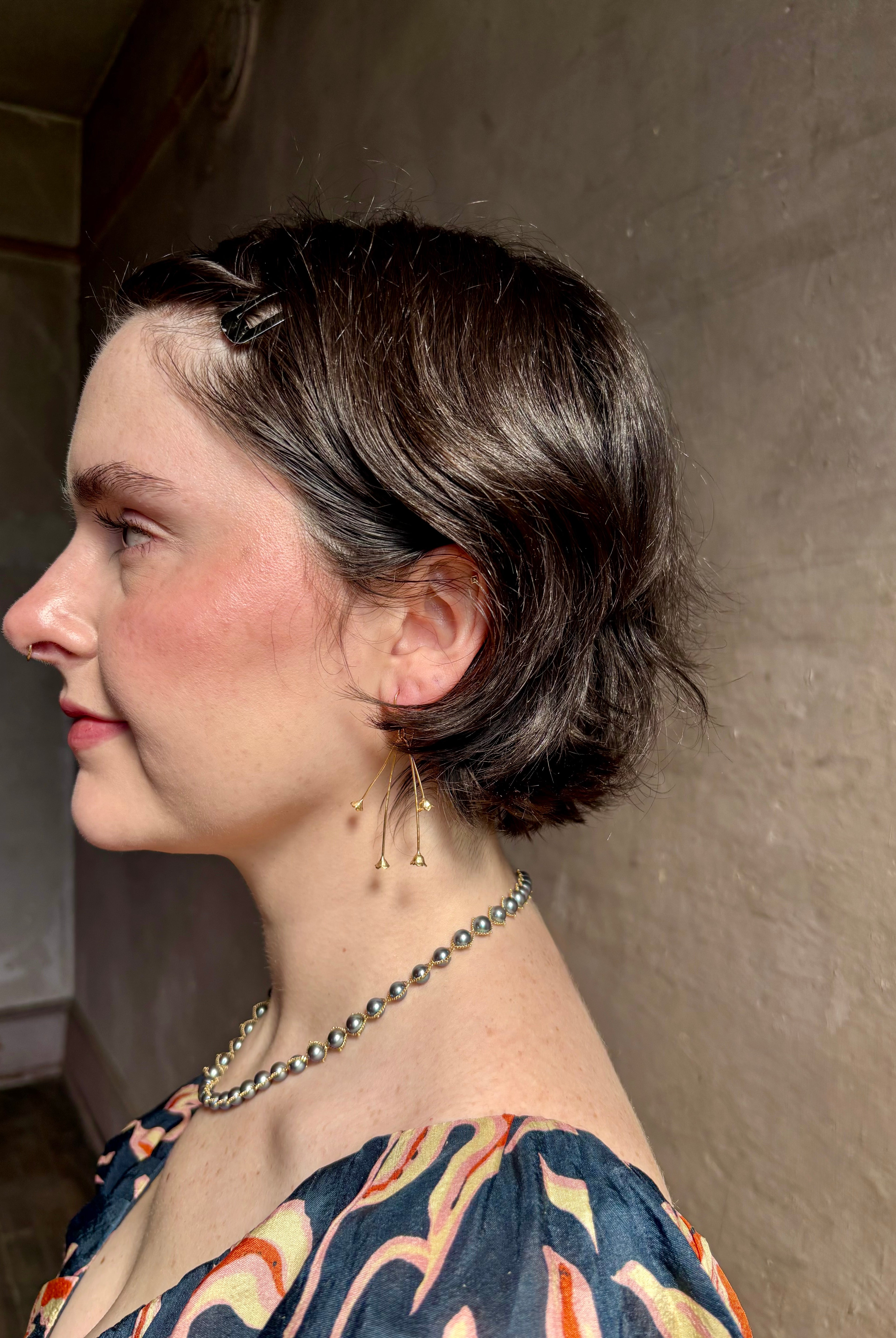 Woman wearing Lily of the Valley Earrings from North Carolna fine jewelry artist Amber Mahler handcrafted 18K yellow gold vermeil with four dangling flower blossoms