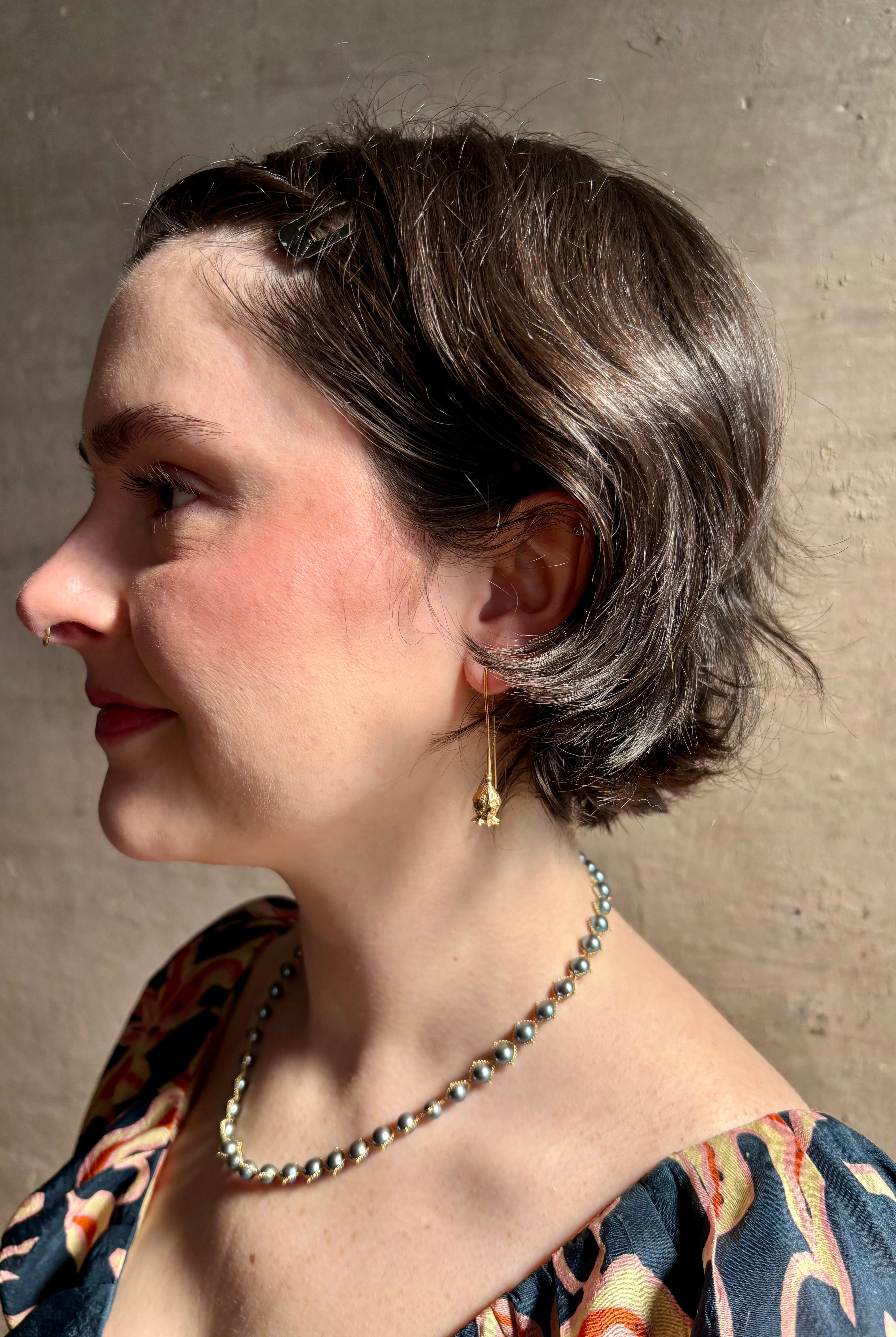 Woman wearing Poppy Pod Drop Earrings from North Carolina fine jewelry artist Amber Mahler handcrafted 18K yellow gold vermeil botanical casting