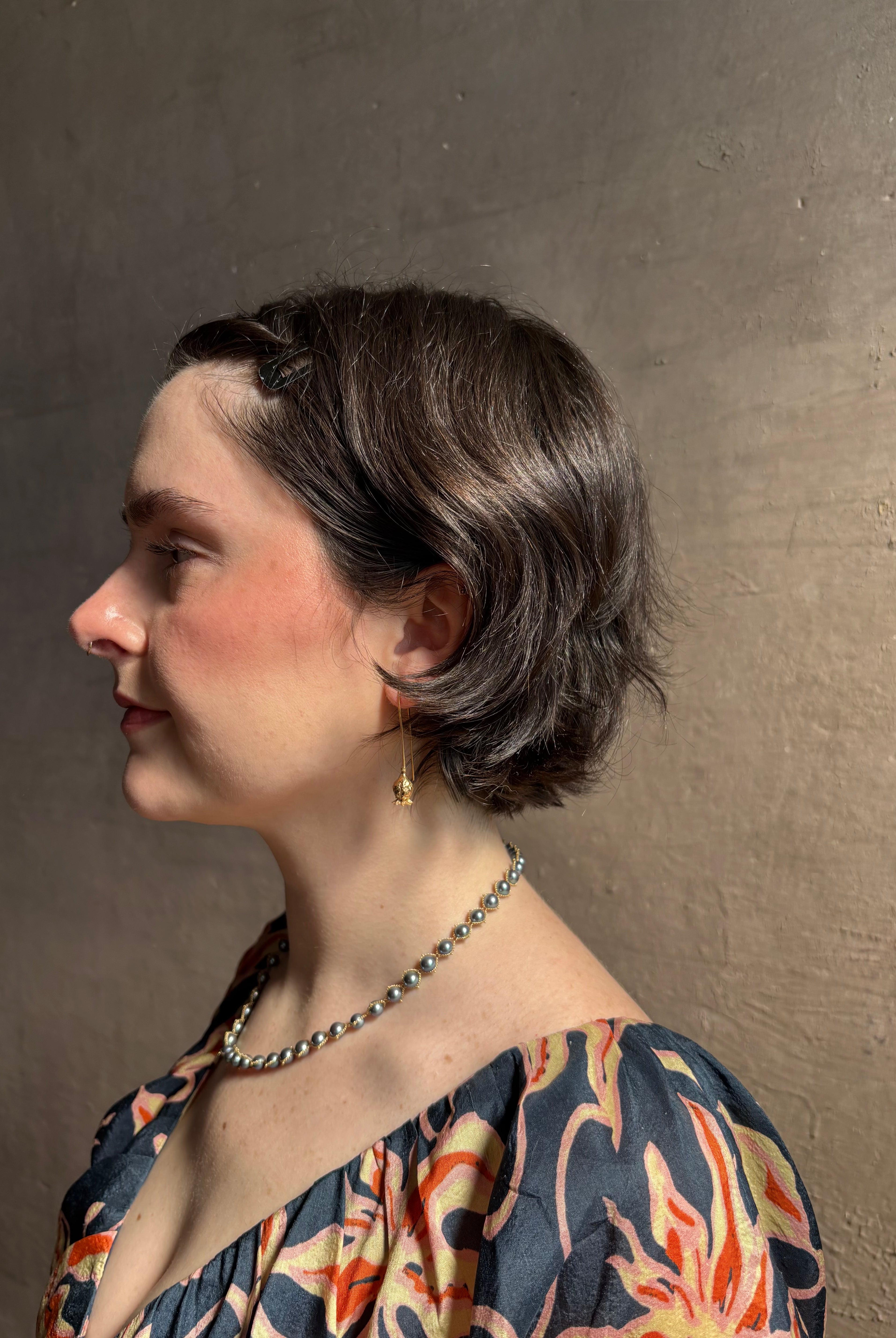 Woman wearing Poppy Pod Drop Earrings from North Carolina fine jewelry artist Amber Mahler handcrafted 18K yellow gold vermeil botanical casting