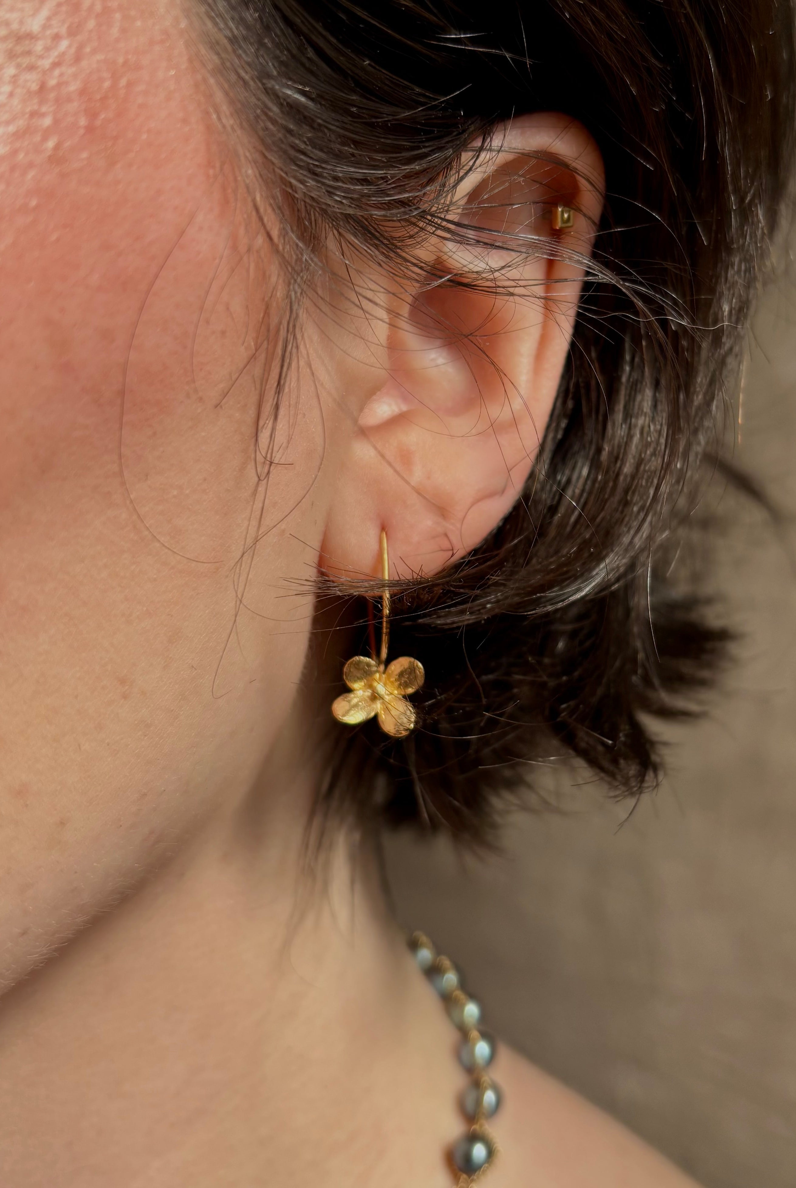 Woman wearing Purslane Rosette Hoop Earrings from North Carolina fine jewelry artist Amber Mahler handcrafted in 18K yellow gold vermeil cast directly from the purslane rosette