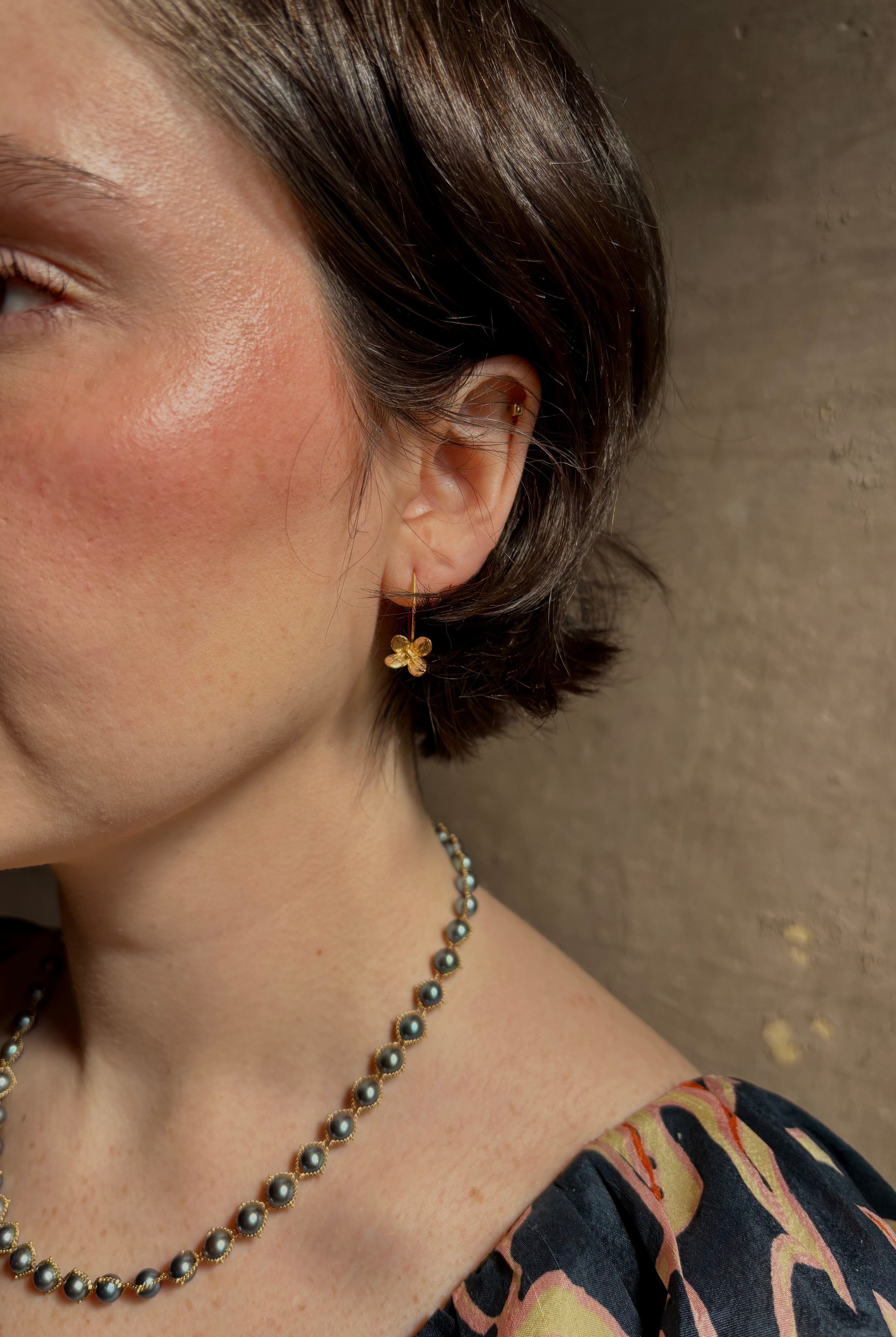 Woman wearing Purslane Rosette Hoop Earrings from North Carolina fine jewelry artist Amber Mahler handcrafted in 18K yellow gold vermeil cast directly from the purslane rosette