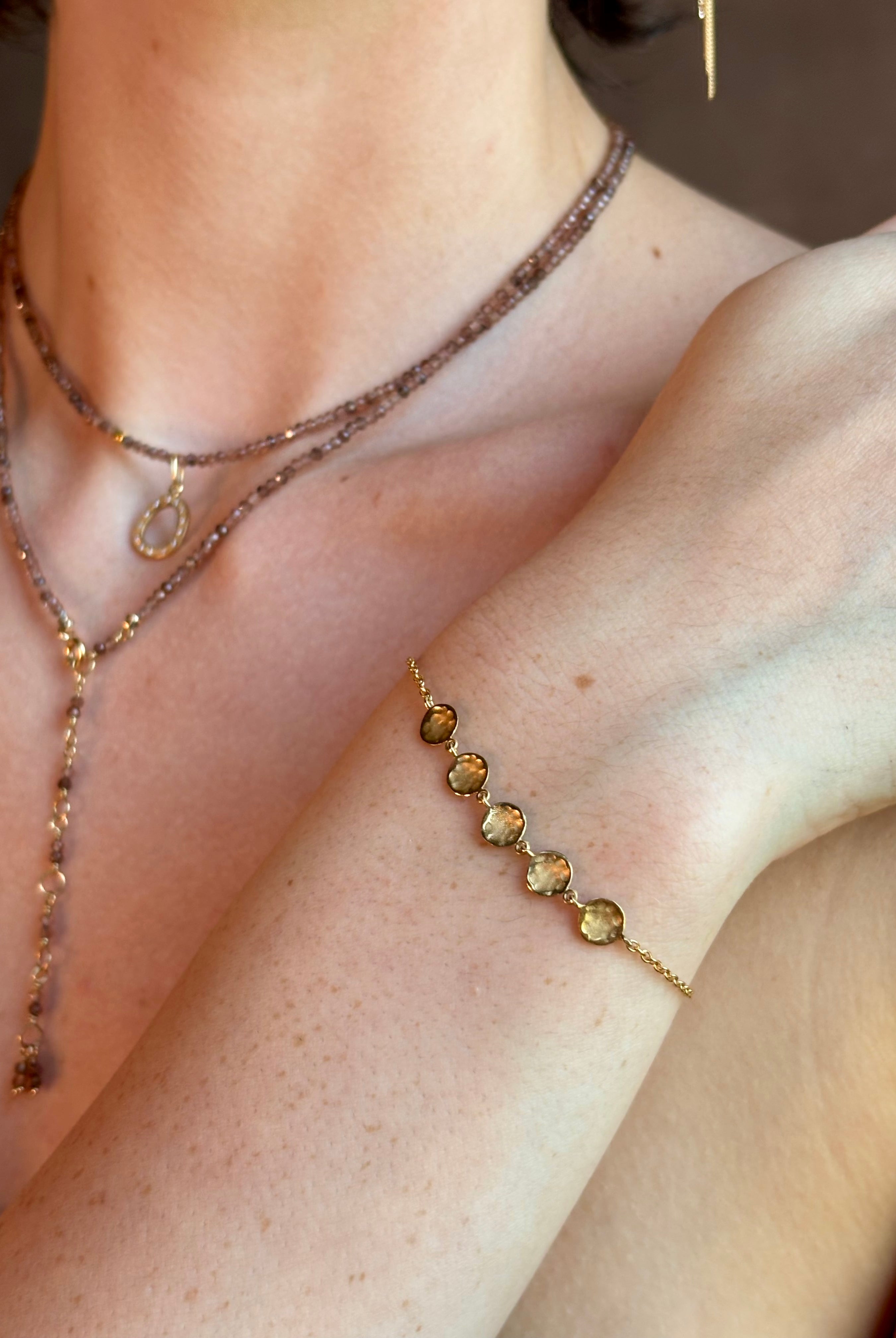 delicate 18K yellow gold bracelet by fine jewelry artist Anne Sportun handcrafted with 5 hammered gold discs