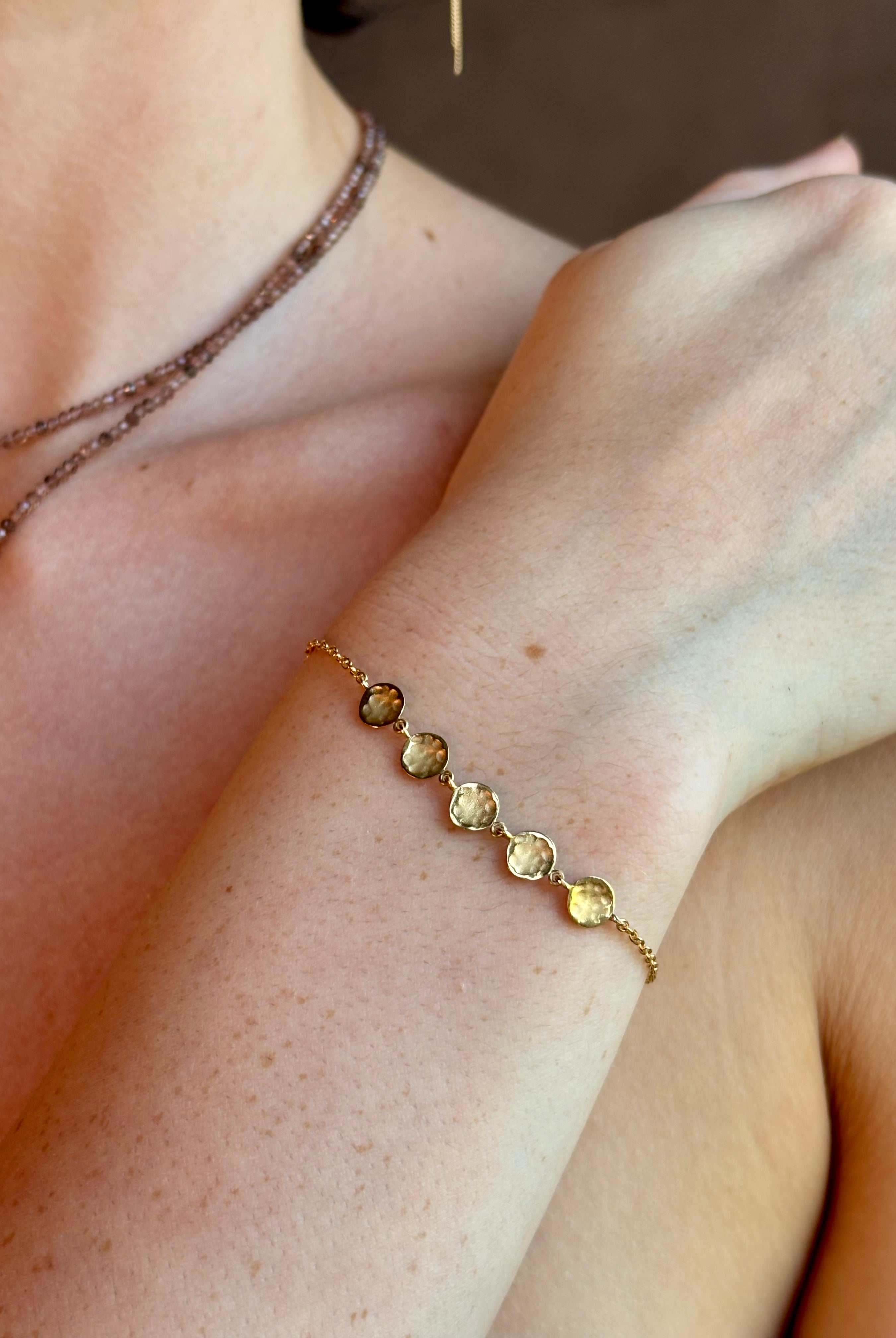 delicate 18K yellow gold bracelet by fine jewelry artist Anne Sportun handcrafted with 5 hammered gold discs