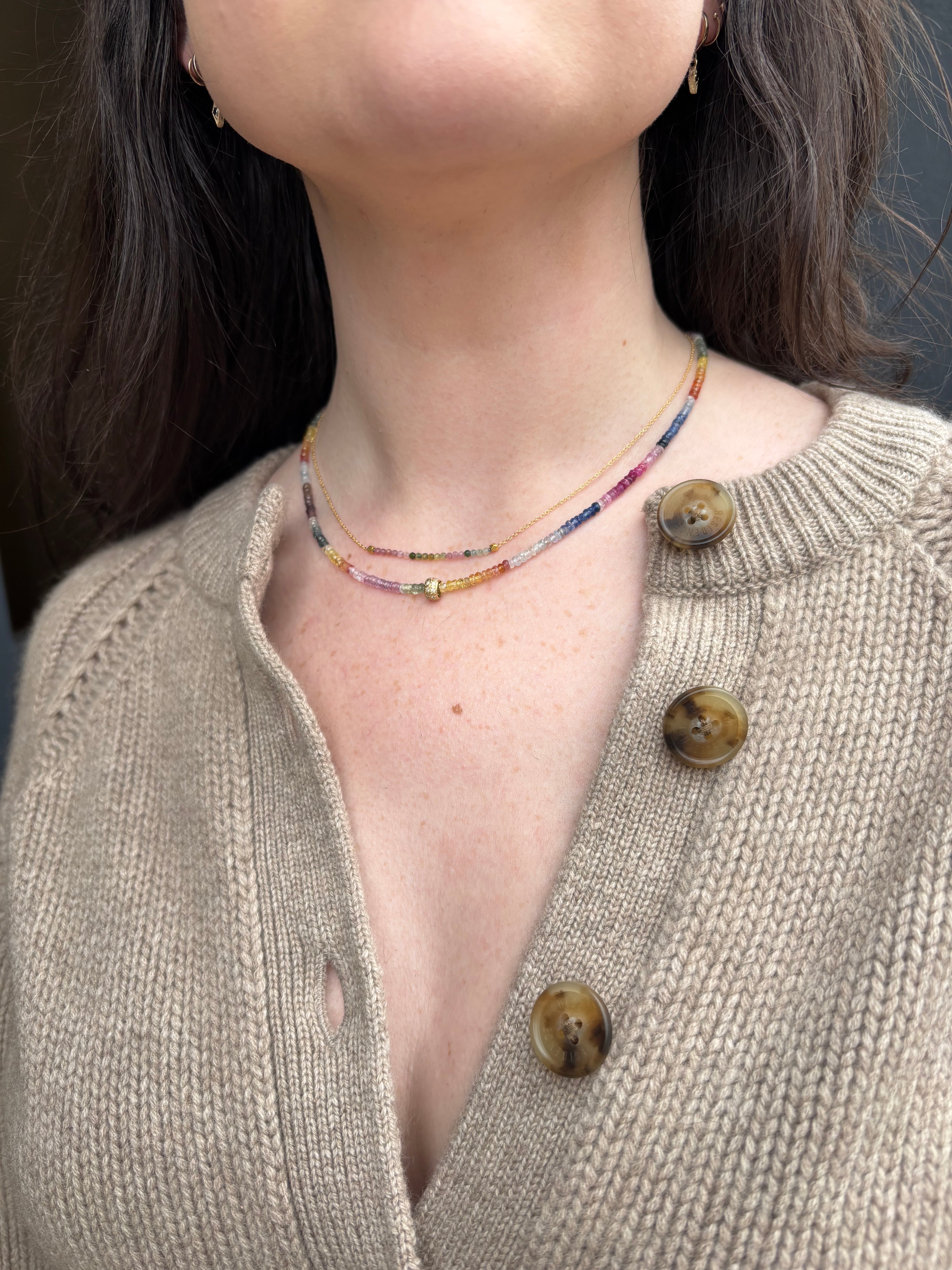 Image of woman wearing fine jewelry designer ANNE SPORTUN Center Watermelon Tourmaline Necklace in 18k yellow gold layered with larger boulder necklace