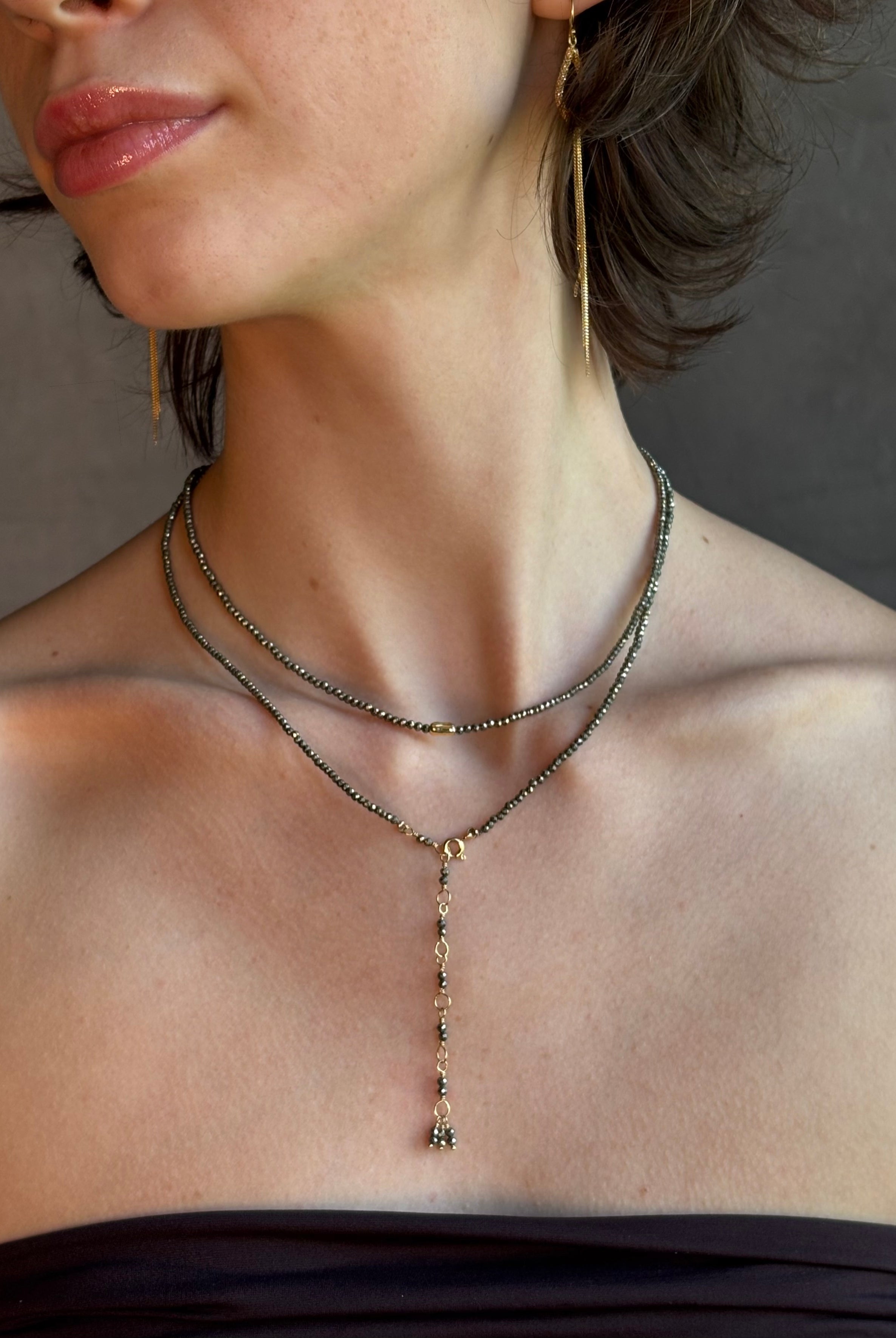 Woman wearing Pyrite River wrap Bracelet from Canadian fine jewelry artist Anne Sportun with pyrite and 18k yellow gold beads that can double as a necklace perfect for travel