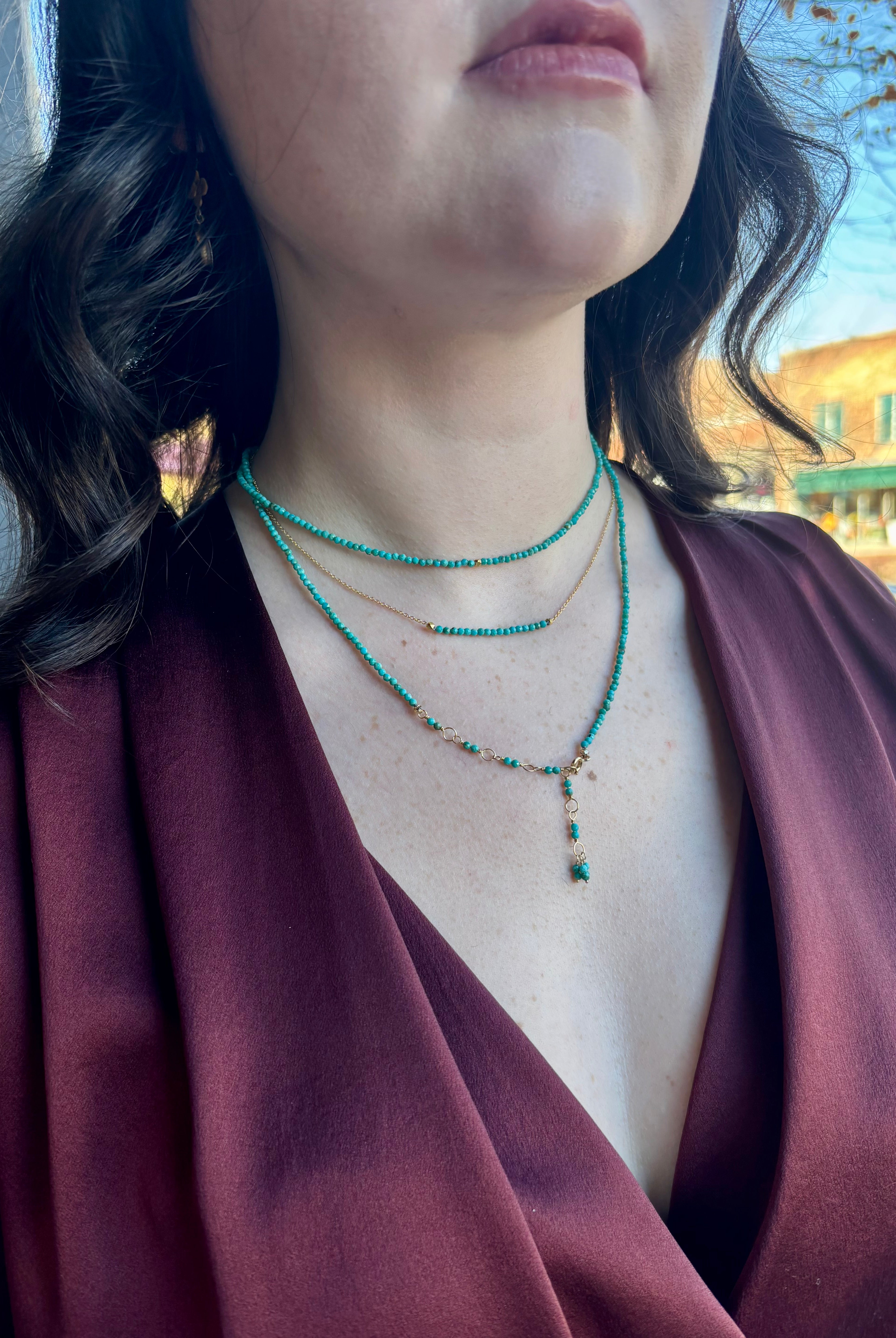 Image of woman wearing Canadian fine Jewelry designer ANNE SPORTUN turquoise wrap Bracelet  as a layering necklace