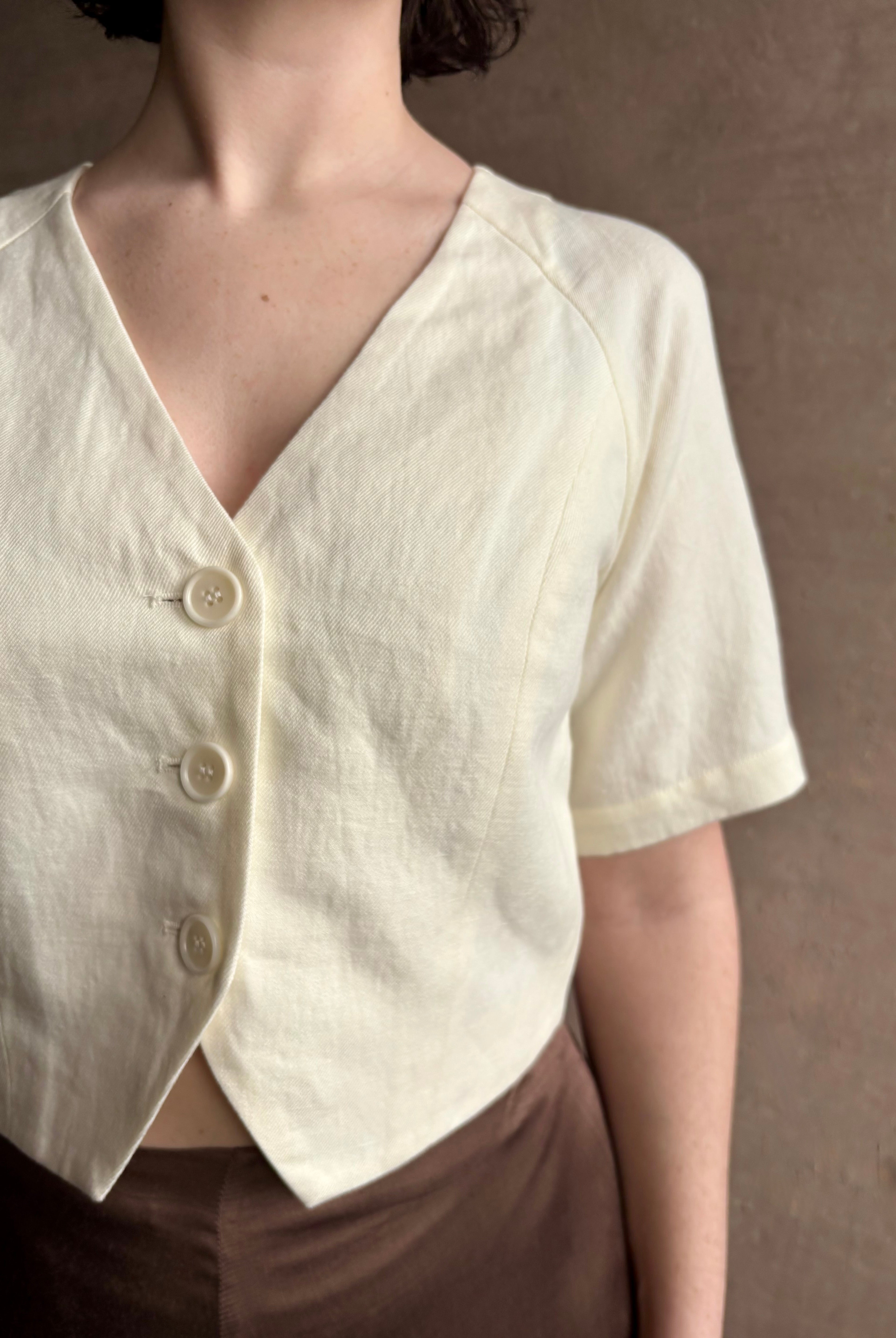 Woman wearing an elevated cream Lia designer Crop Top from Apiece Apart crafted in a breathable summer blend of organic cotton and linen