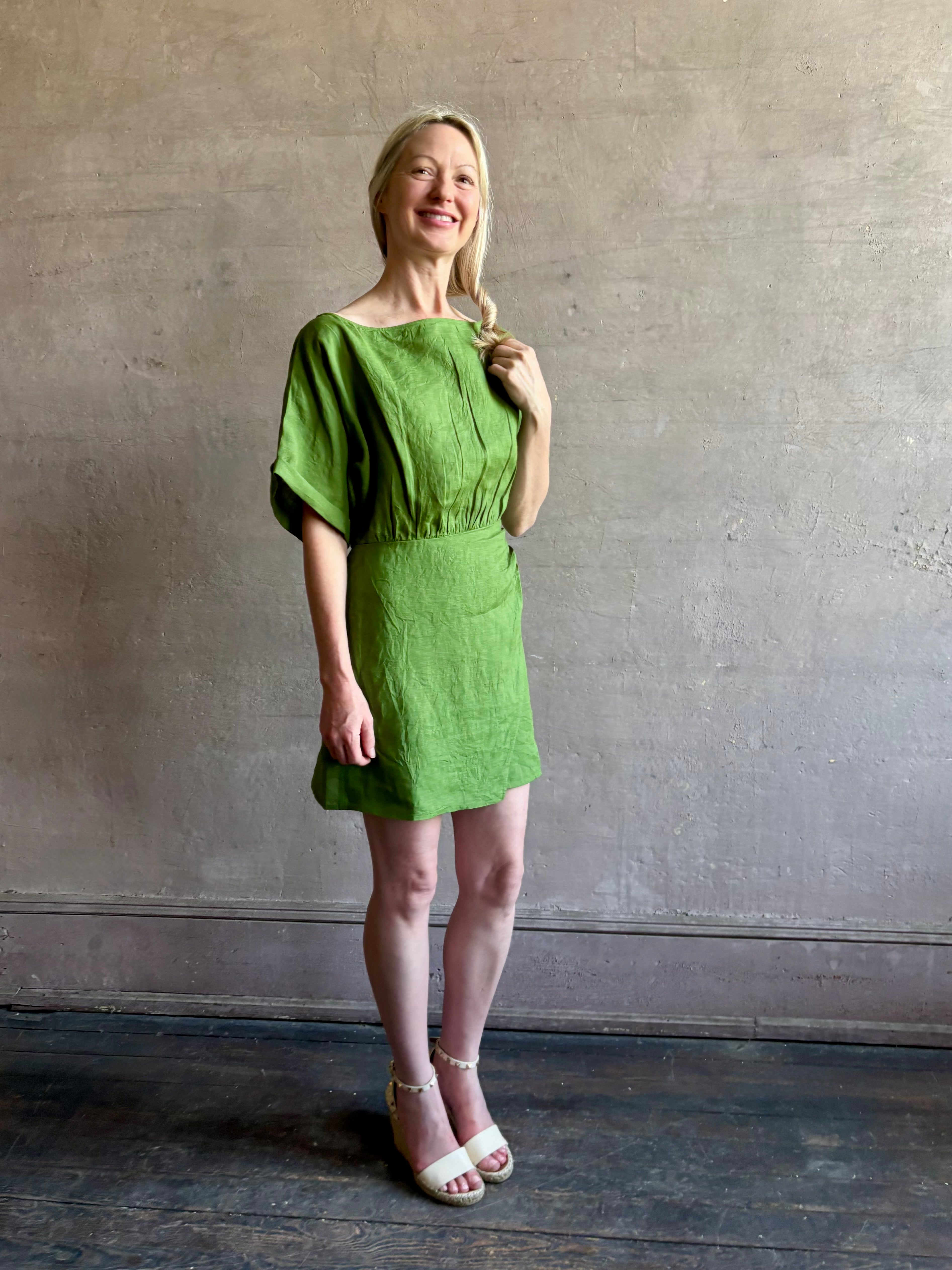 Mature woman wearing the effortlessly Sigrun Mini summer Dress from Apiece Apart rendered in 100% linen with a boat neck, loose half sleeves and blouson style