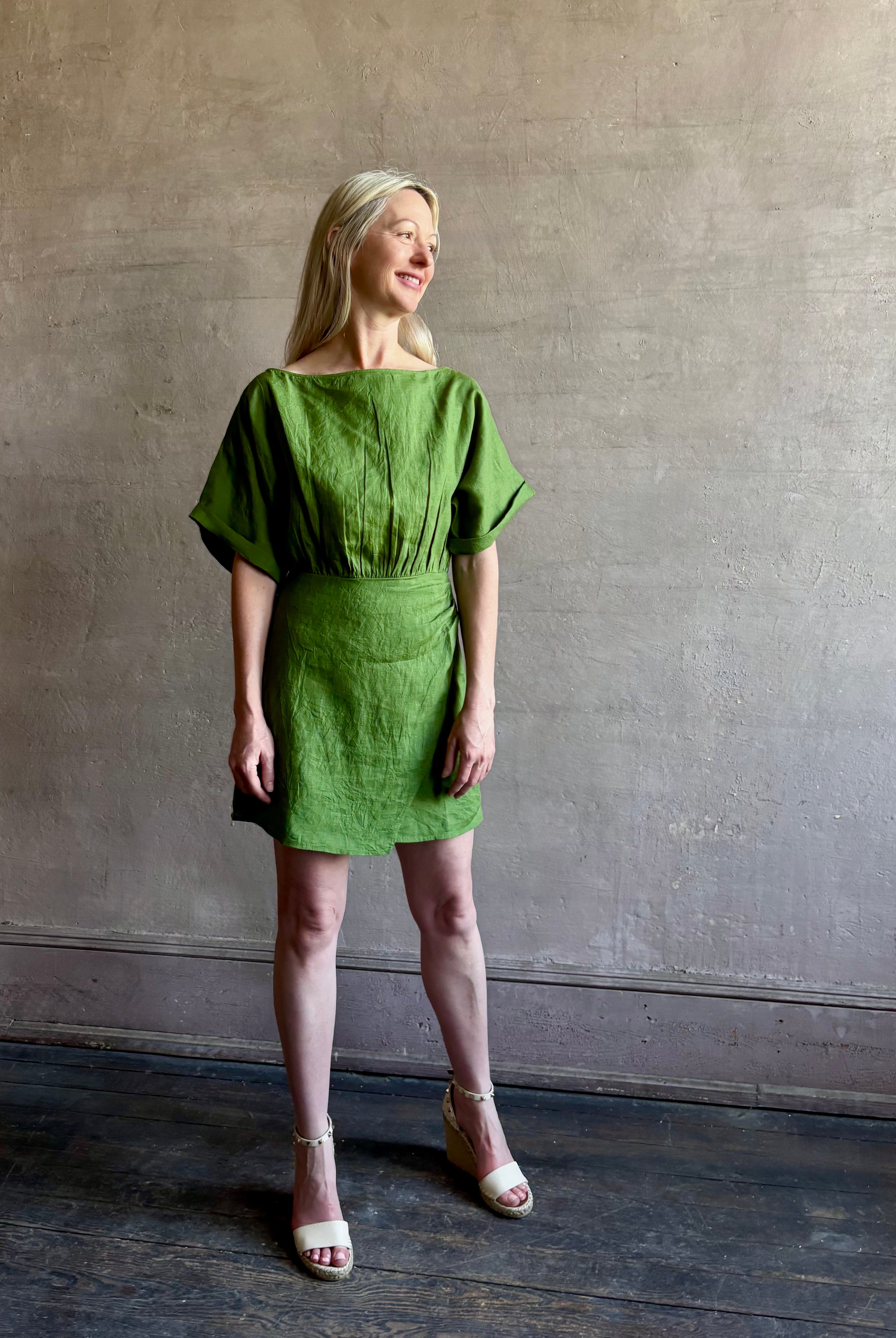 Mature woman wearing the effortlessly Sigrun Mini summer Dress from Apiece Apart rendered in 100% linen with a boat neck, loose half sleeves and blouson style