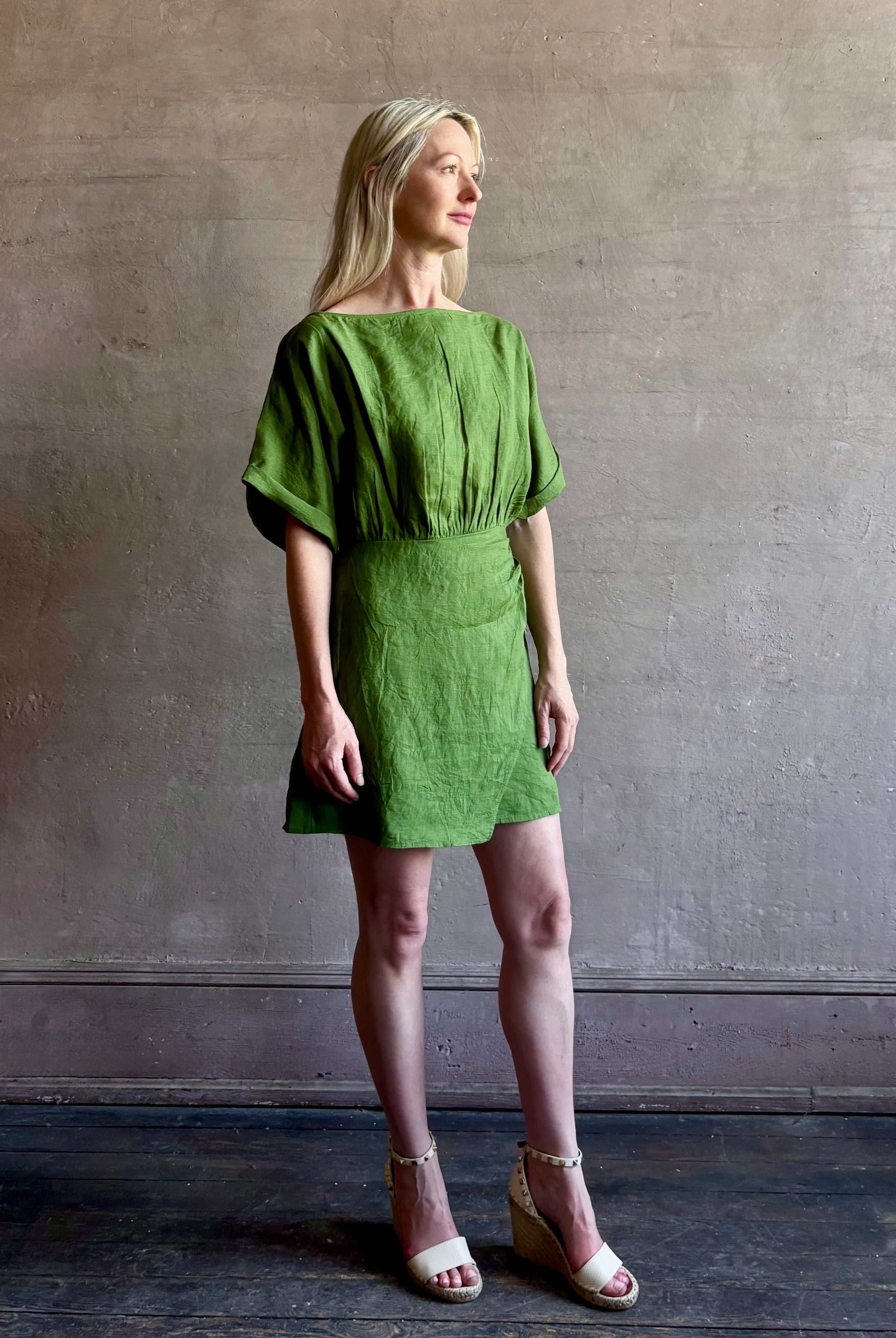 Mature woman wearing the effortlessly Sigrun Mini summer Dress from Apiece Apart rendered in 100% linen with a boat neck, loose half sleeves and blouson style