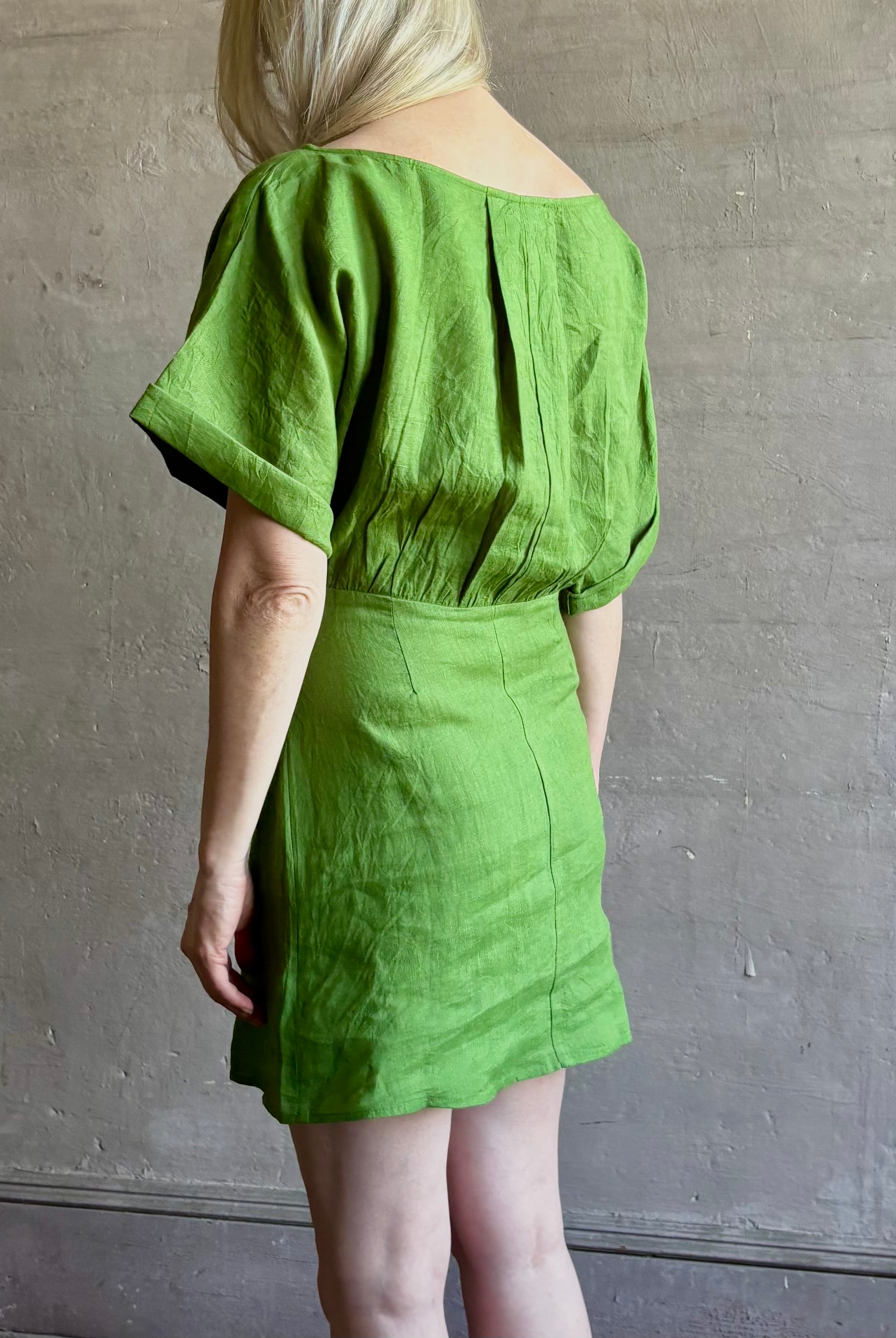 Mature woman wearing the effortlessly Sigrun Mini summer Dress from Apiece Apart rendered in 100% linen with a boat neck, loose half sleeves and blouson style