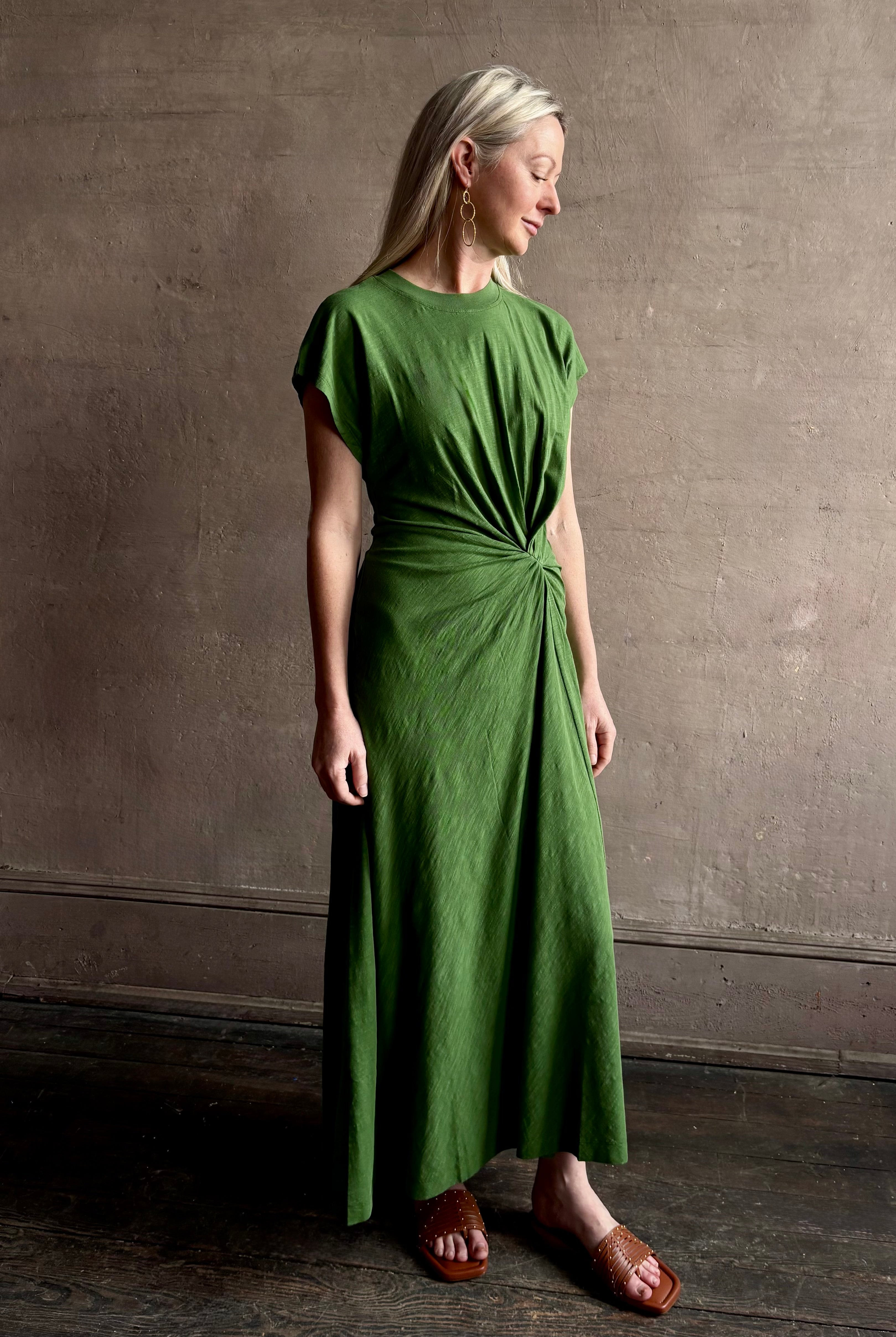Mature woman wearing Volta Twist maxi Dress from Apiece Apart in a comfy green organic cotton jersey with short sleeves and crew neck