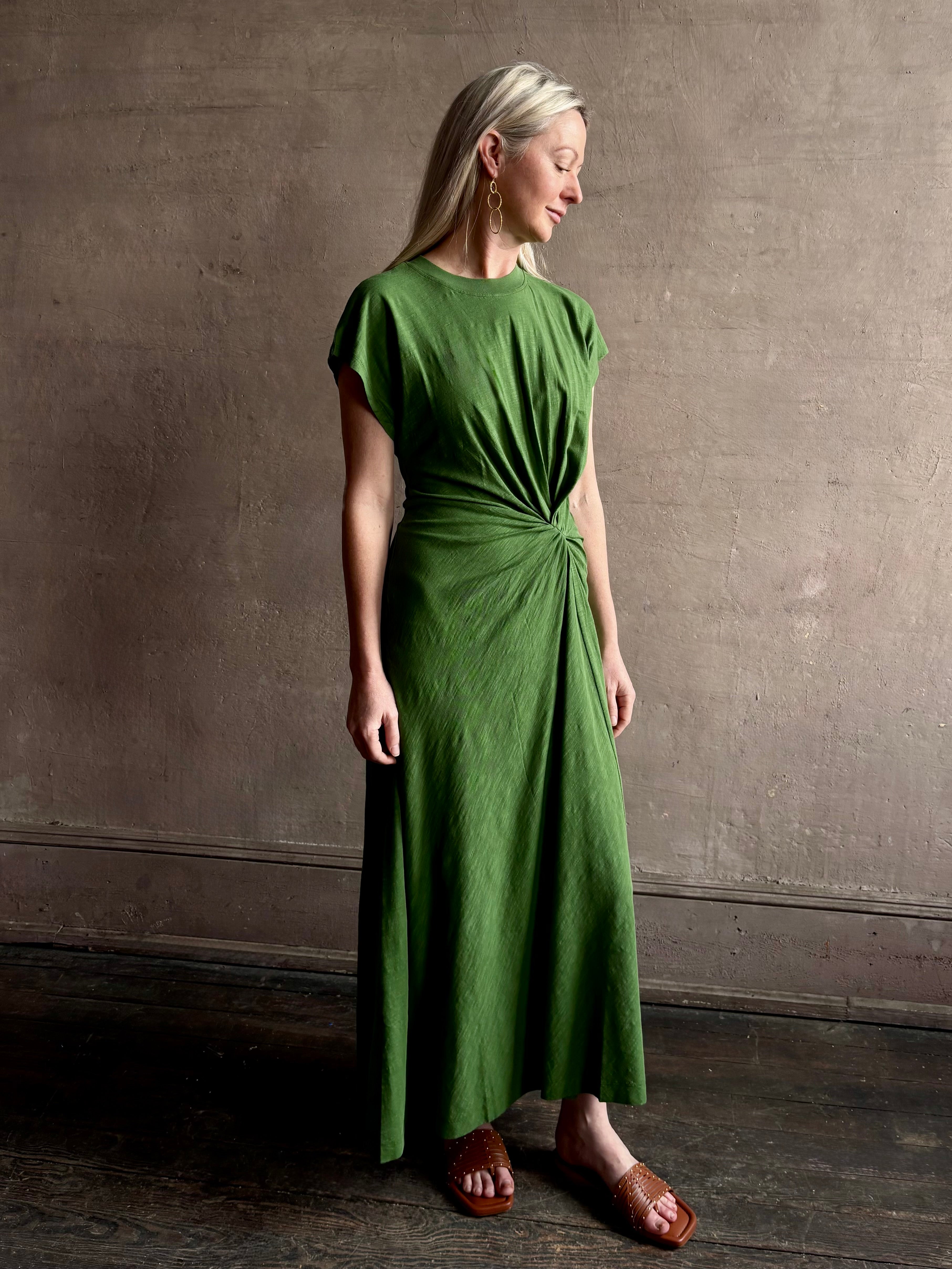 Mature woman wearing Volta Twist maxi Dress from Apiece Apart in a comfy green organic cotton jersey with short sleeves and crew neck