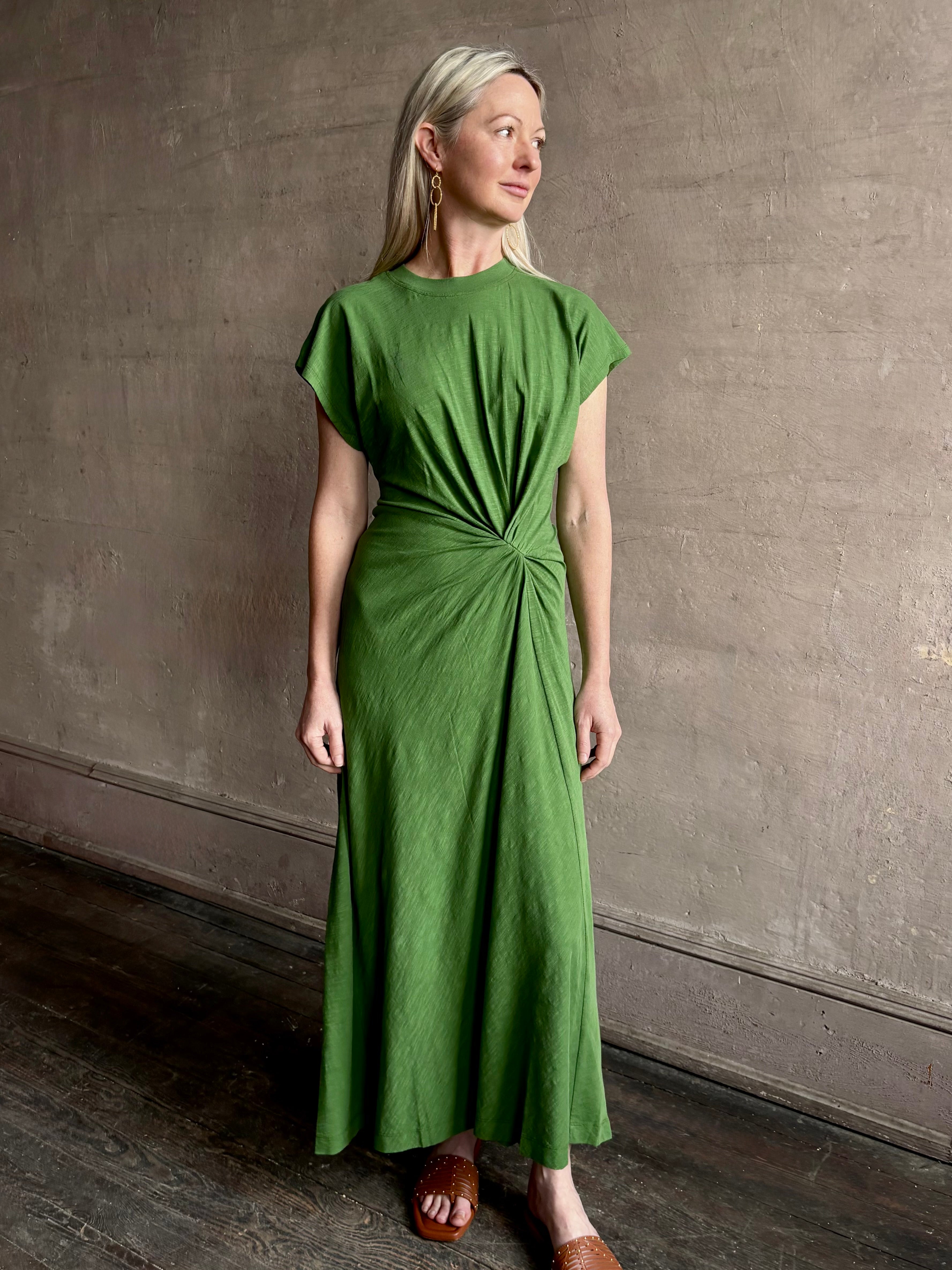 Mature woman wearing Volta Twist maxi Dress from Apiece Apart in a comfy green organic cotton jersey with short sleeves and crew neck