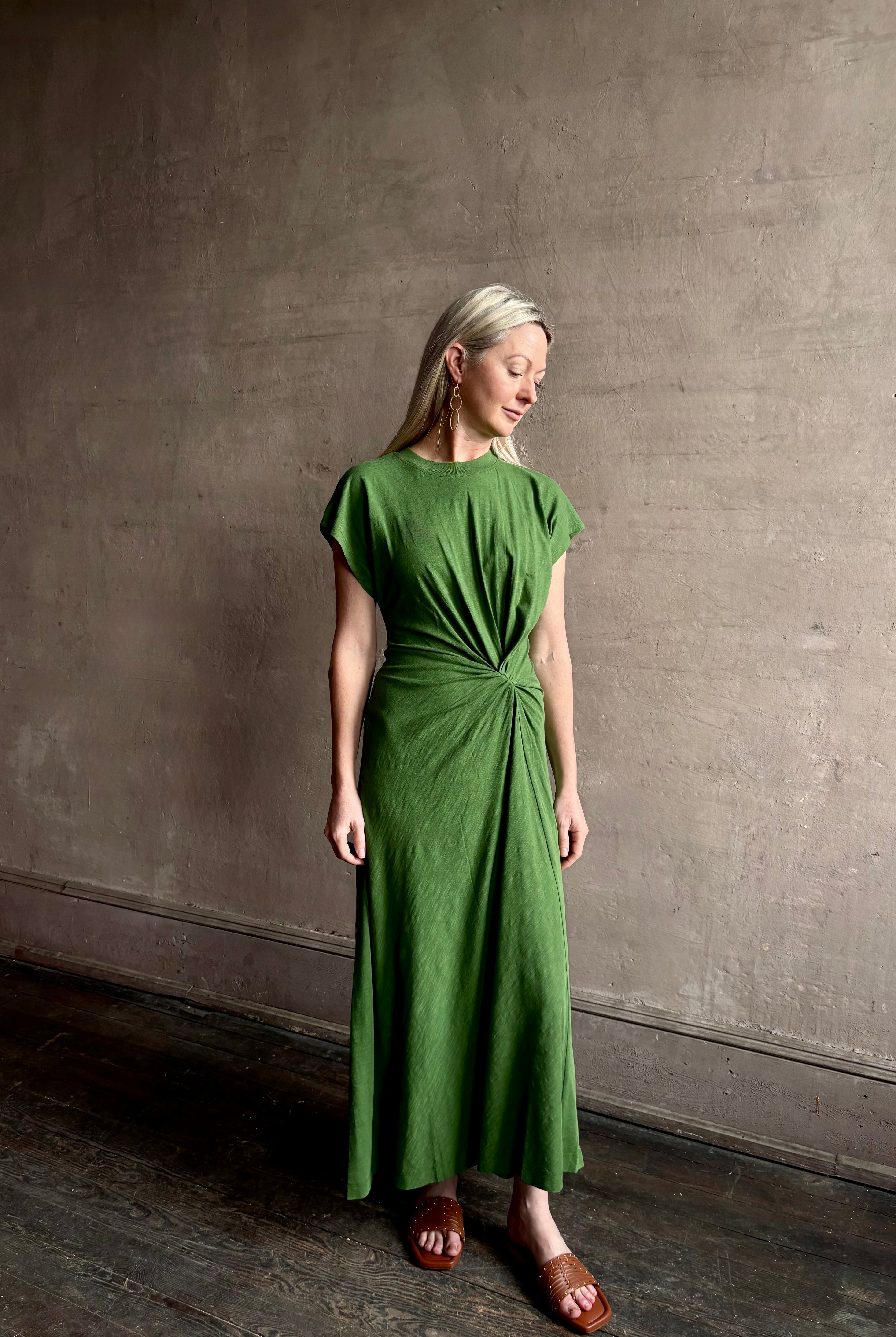 Mature woman wearing Volta Twist maxi Dress from Apiece Apart in a comfy green organic cotton jersey with short sleeves and crew neck