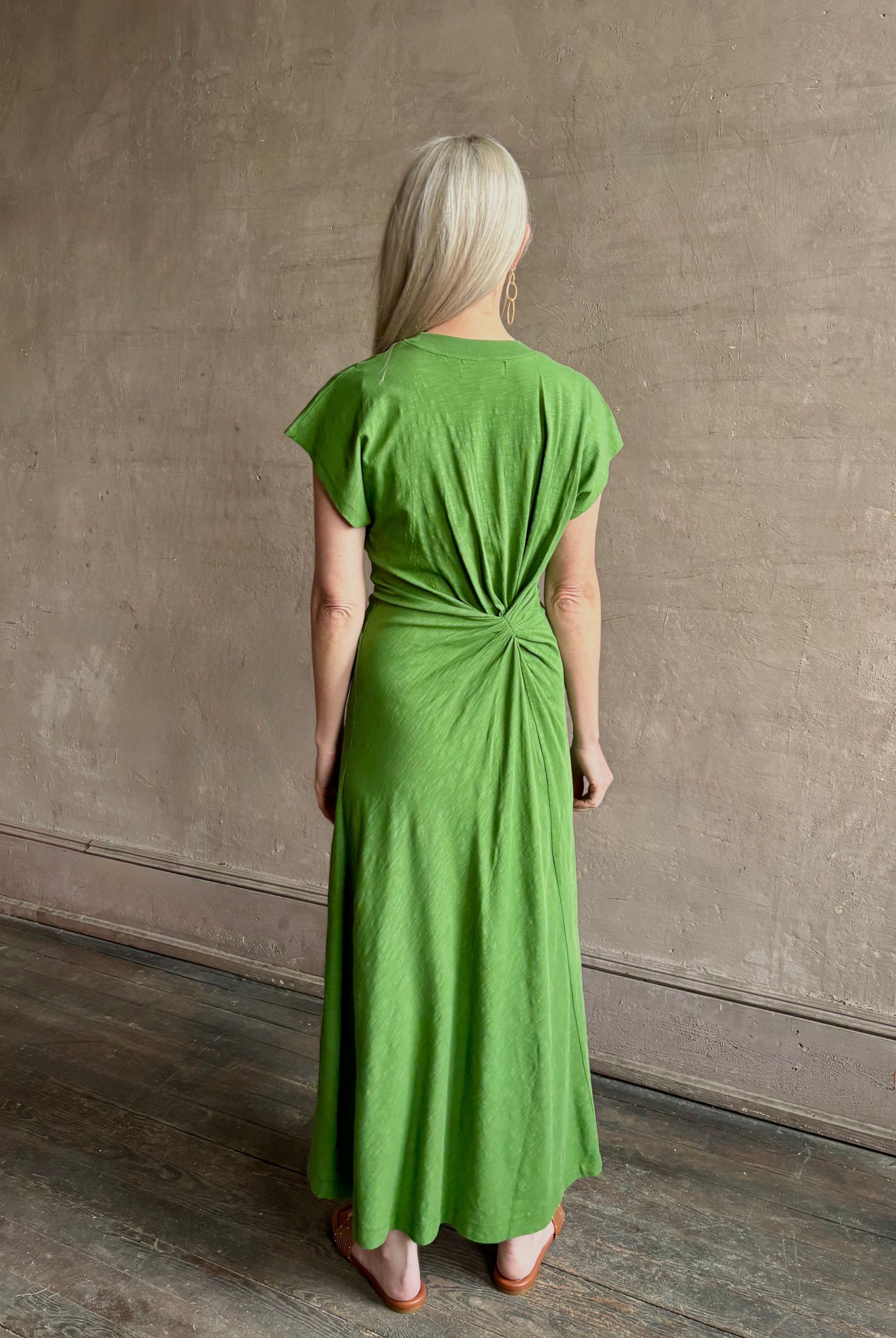 Mature woman wearing Volta Twist maxi Dress from Apiece Apart in a comfy green organic cotton jersey with short sleeves and crew neck