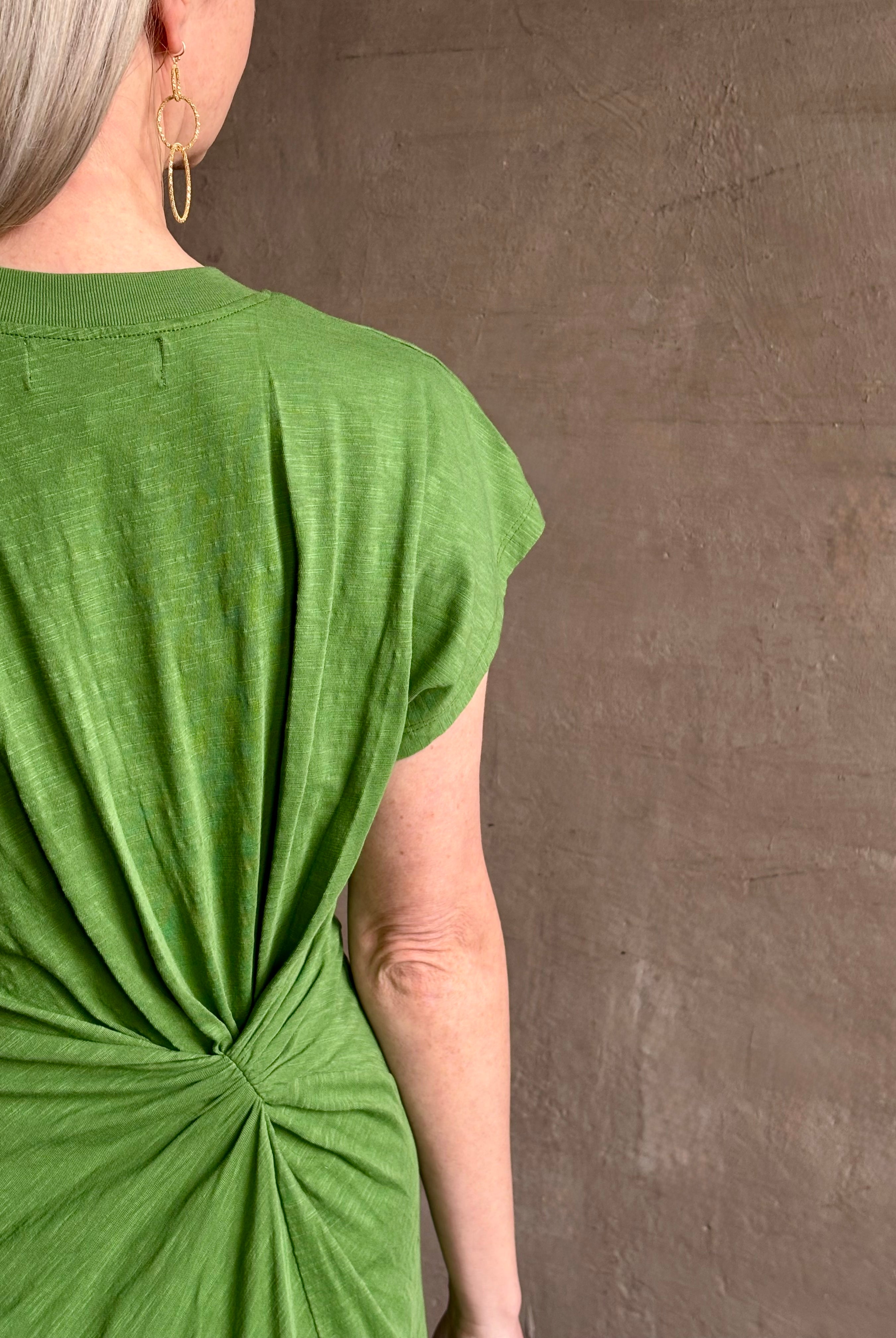 Mature woman wearing Volta Twist maxi Dress from Apiece Apart in a comfy green organic cotton jersey with short sleeves and crew neck