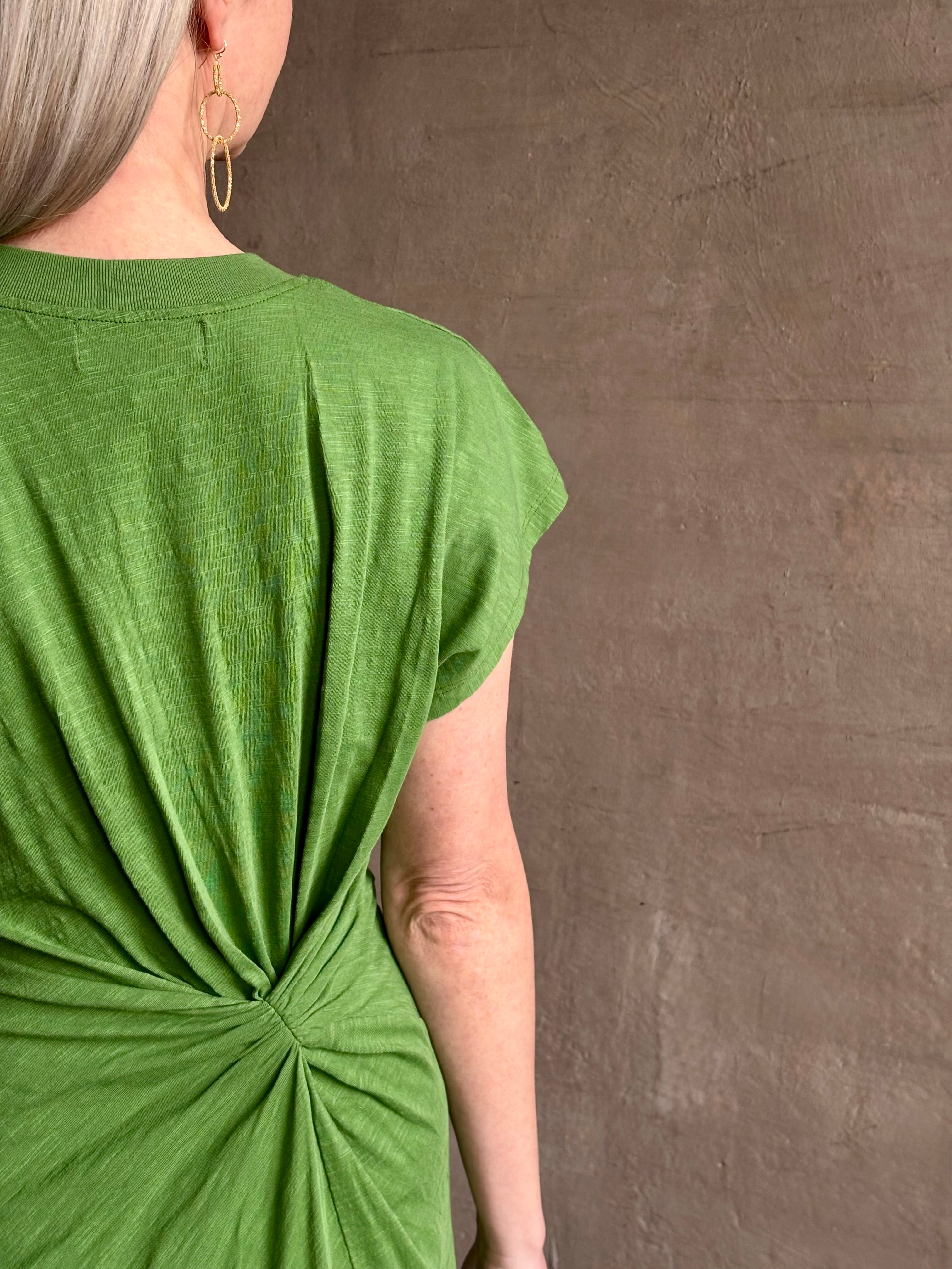 Mature woman wearing Volta Twist maxi Dress from Apiece Apart in a comfy green organic cotton jersey with short sleeves and crew neck