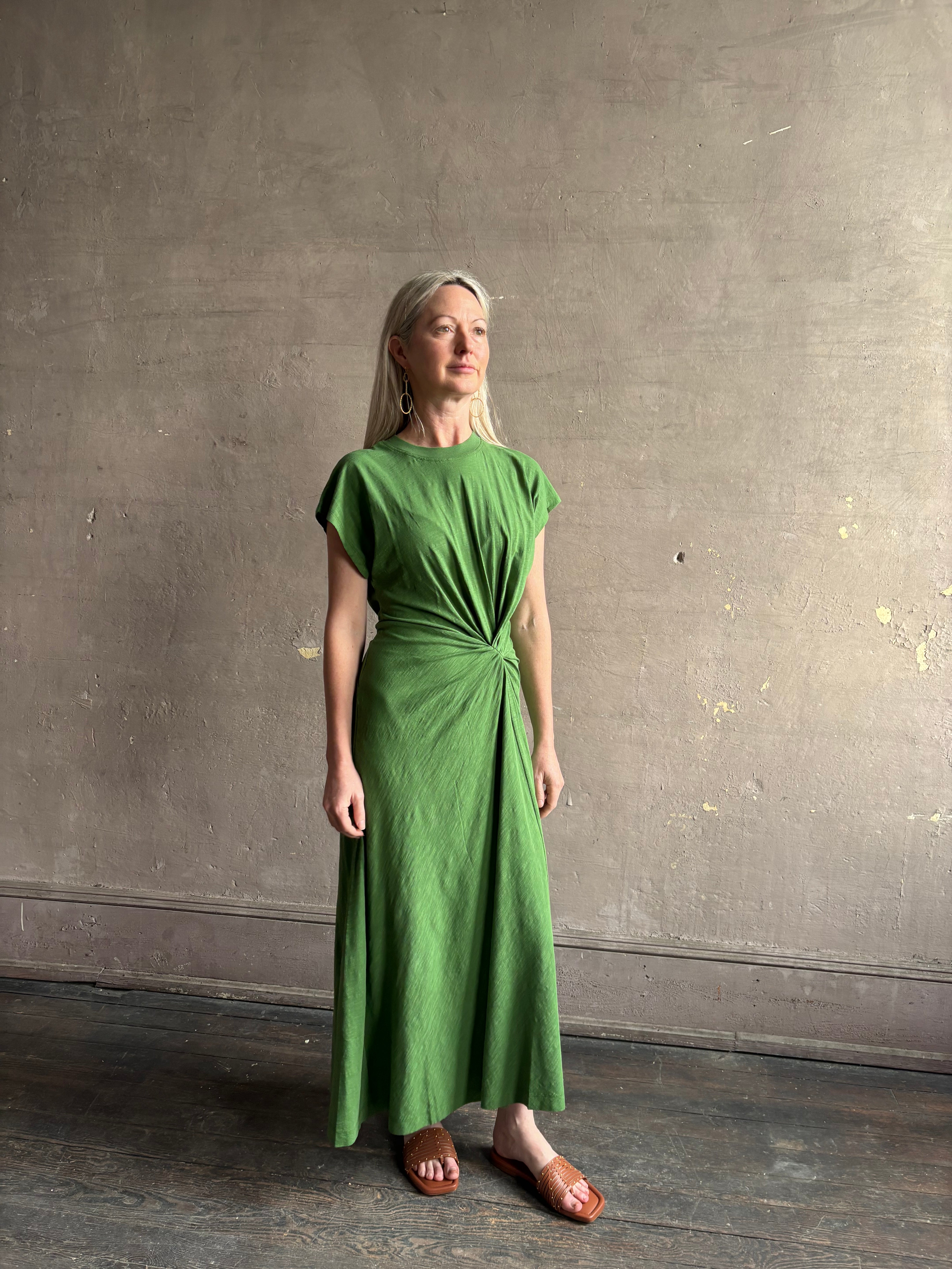 Mature woman wearing Volta Twist maxi Dress from Apiece Apart in a comfy green organic cotton jersey with short sleeves and crew neck