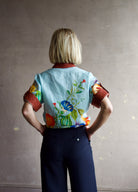 Image of the back of a woman wearing the Alemais Dahlia top, Ulla Johnson Gia Belt and Apiece Apart Cara Wide leg trousers.