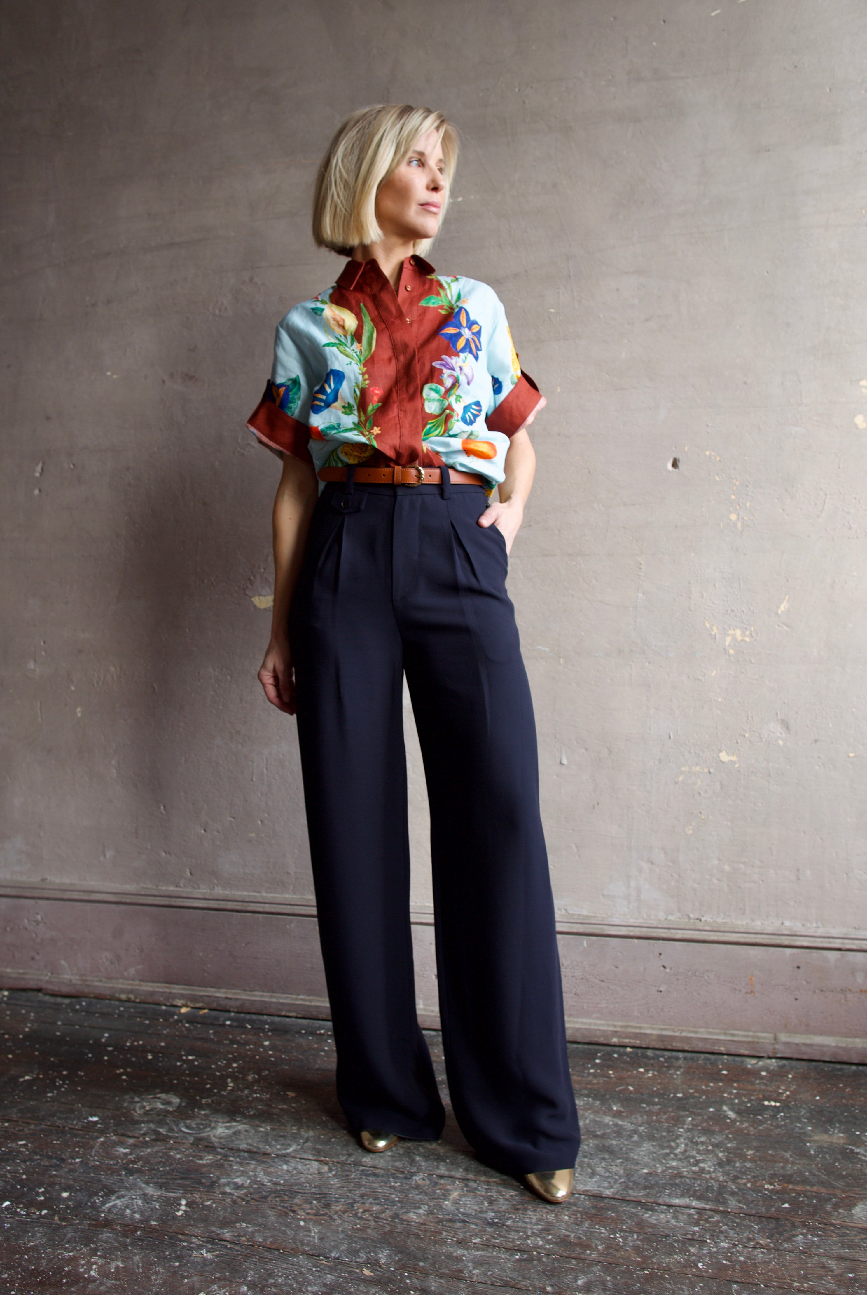 Image of a woman wearing the Alemais Dahlia top, Ulla Johnson Gia Belt, Elise Ruffle Heels and Apiece Apart Cara Wide leg trousers.