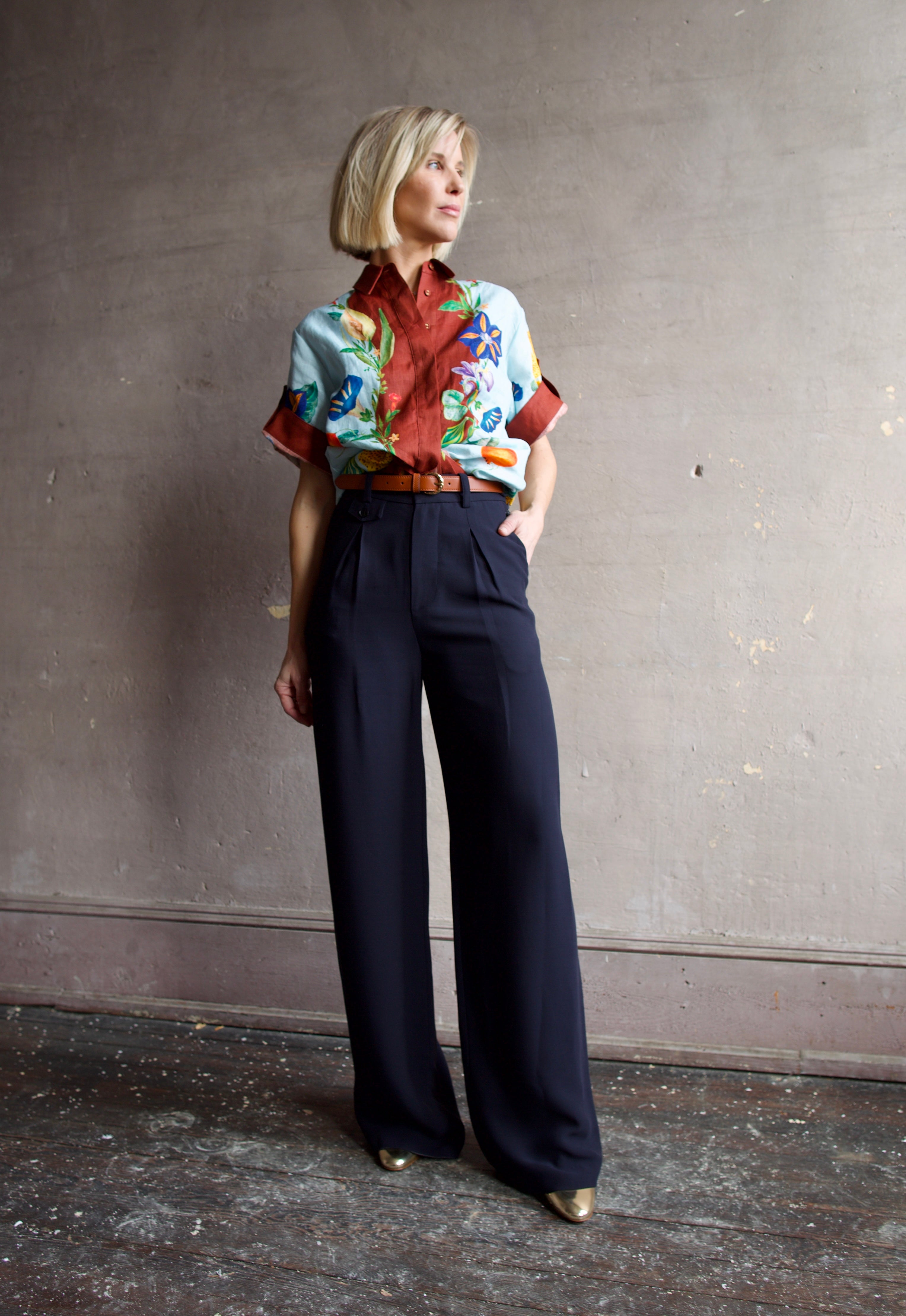 Image of a woman wearing the Alemais Dahlia top, Ulla Johnson Gia Belt, Elise Ruffle Heels and Apiece Apart Cara Wide leg trousers.