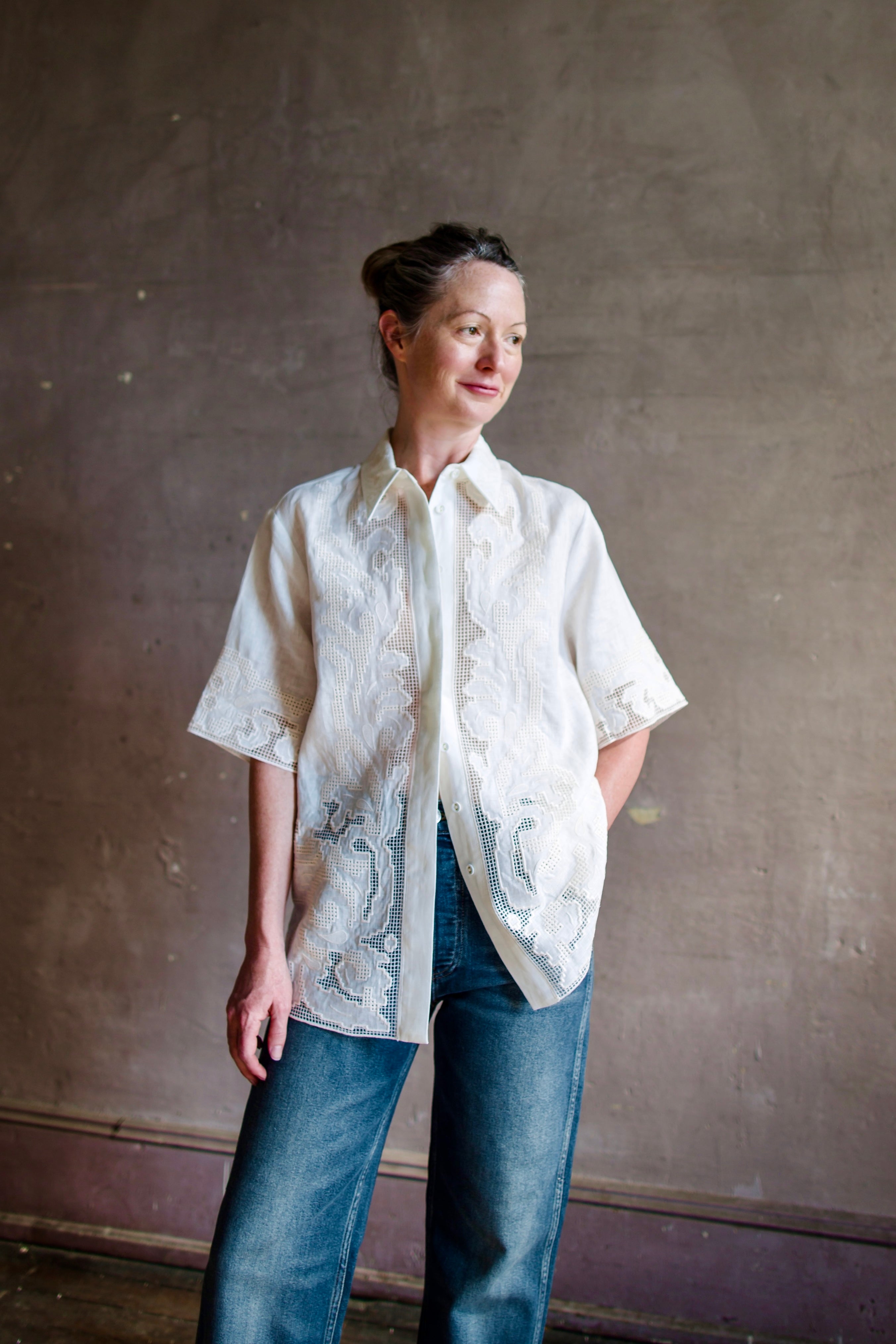 Mature woman wearing white Alemais Pegasus linen shirt with collar and embroidered cut out detail