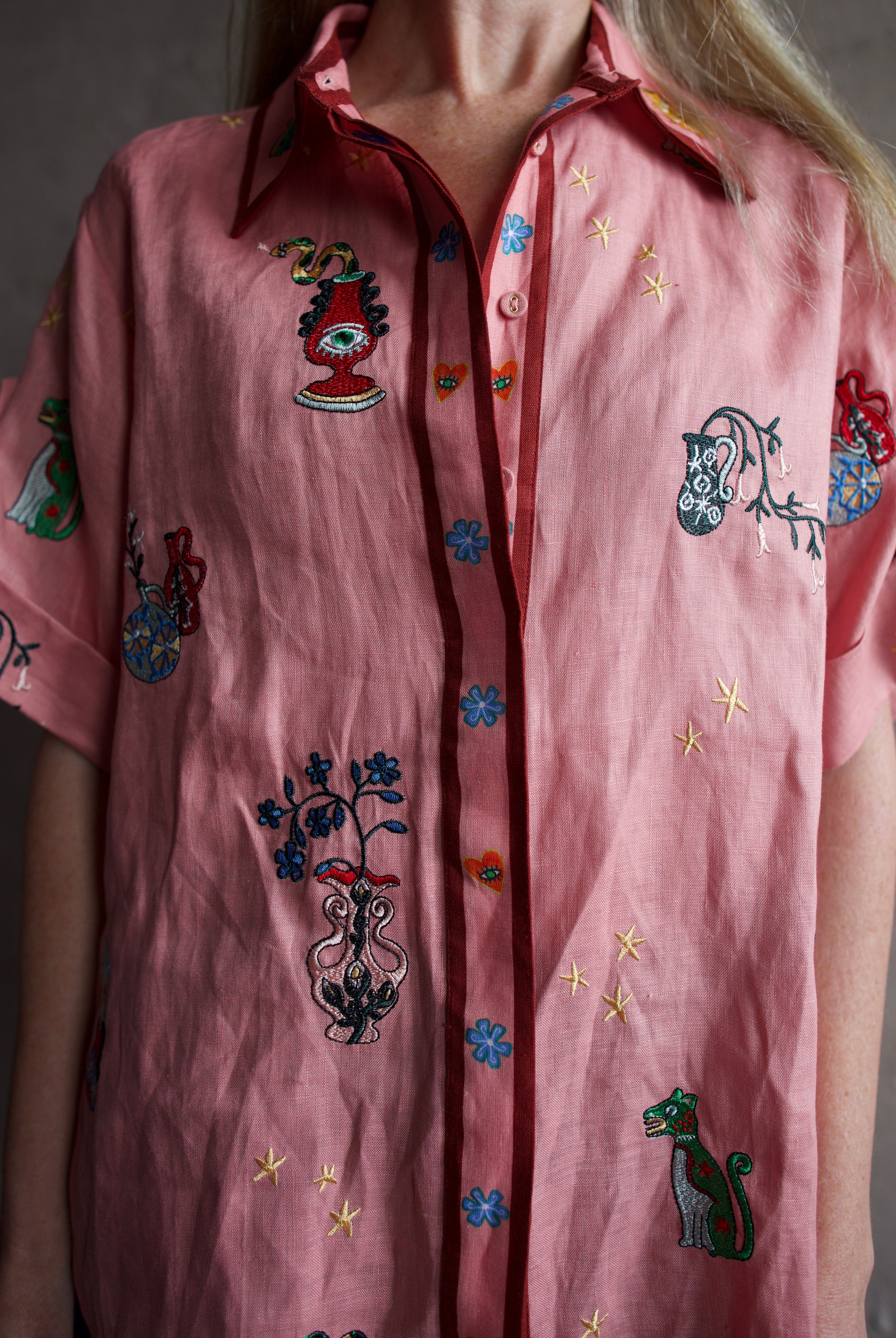 The closeup image of a woman wearing the Alemais Timmy embroidered shirt