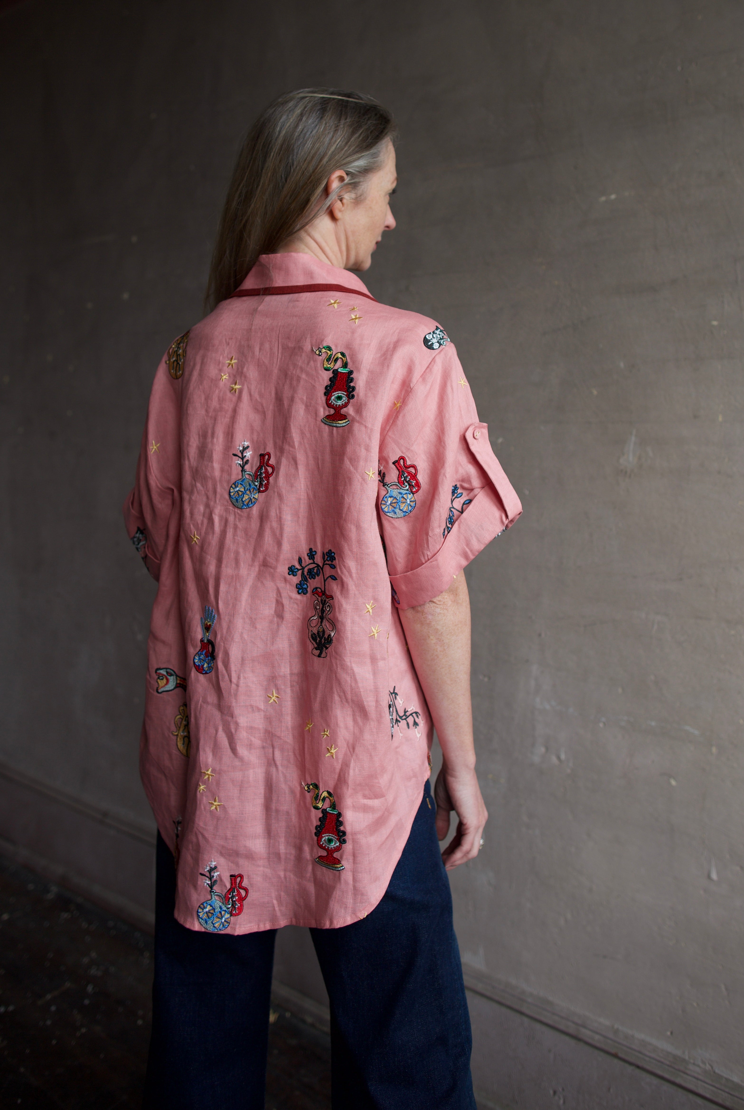 Image of the back of a woman wearing the Alemais Timmy embroidered shirt and Re/Done Wide Leg crop jeans