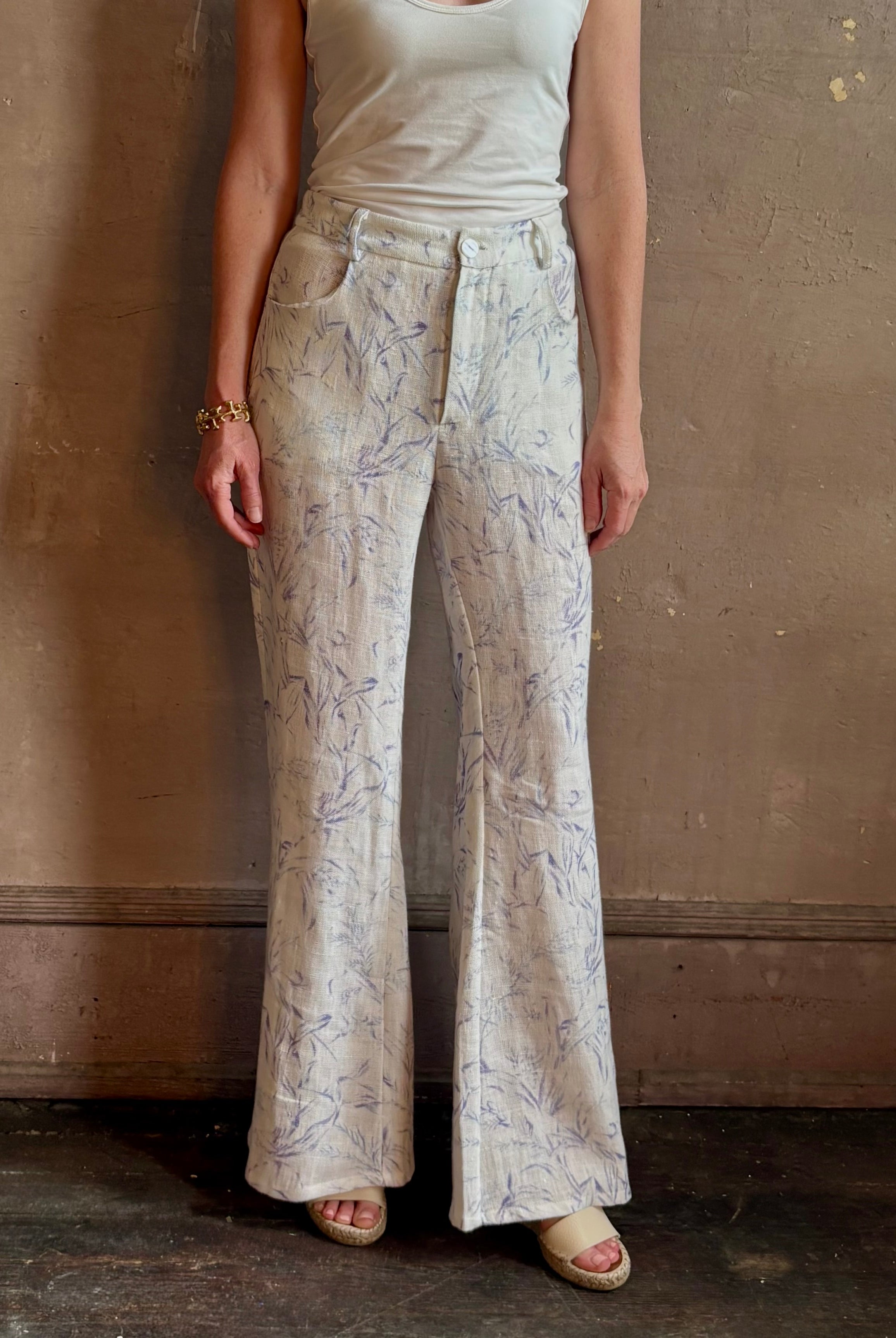 Woman wearing luxury designer Alix of Bohemia bunny toile linen trousers in white with blue print flare high rise