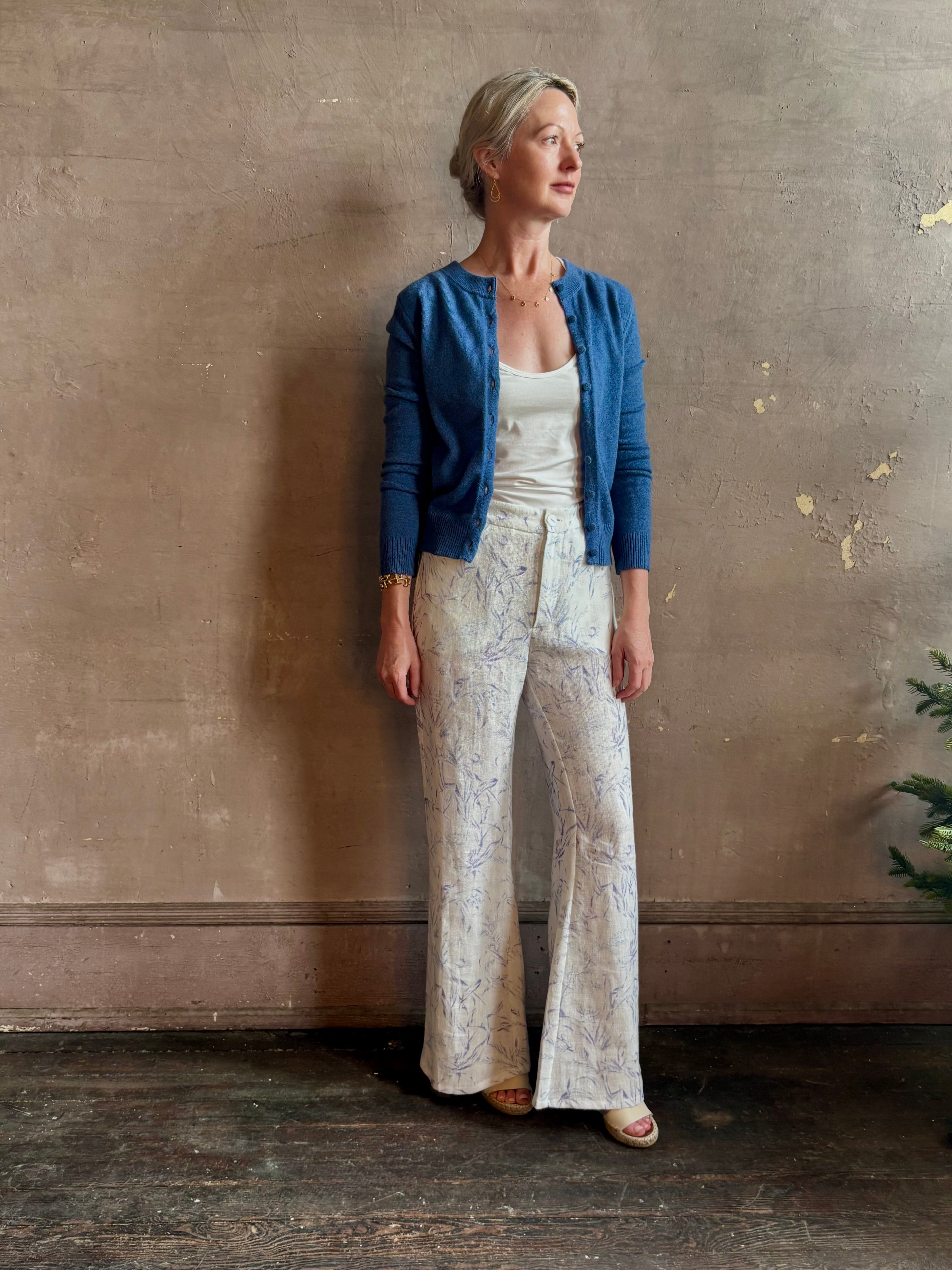 Woman wearing luxury designer Alix of Bohemia bunny toile linen trousers in white with blue print flare high rise