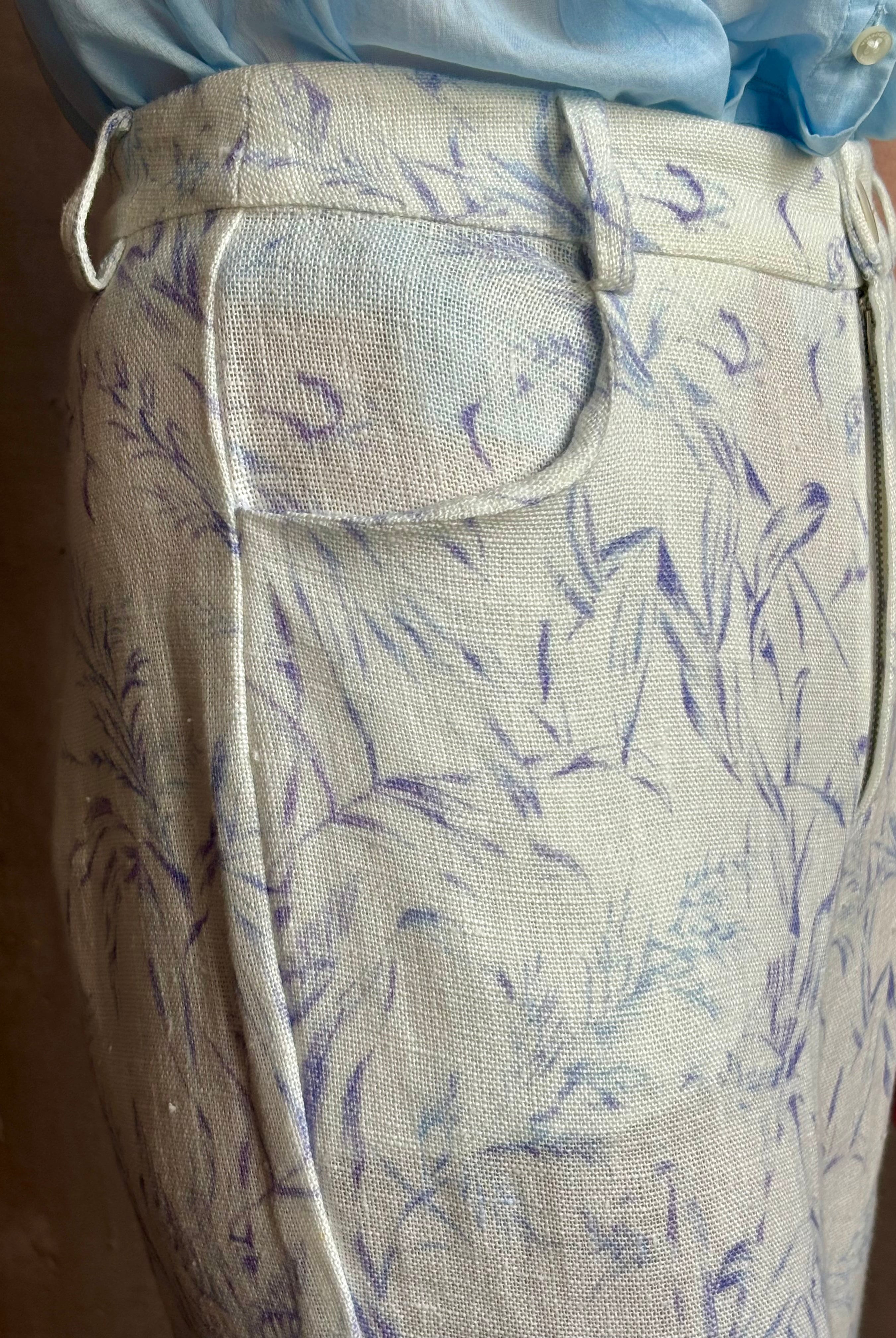 Woman wearing luxury designer Alix of Bohemia bunny toile lightweight linen trousers in white with blue print