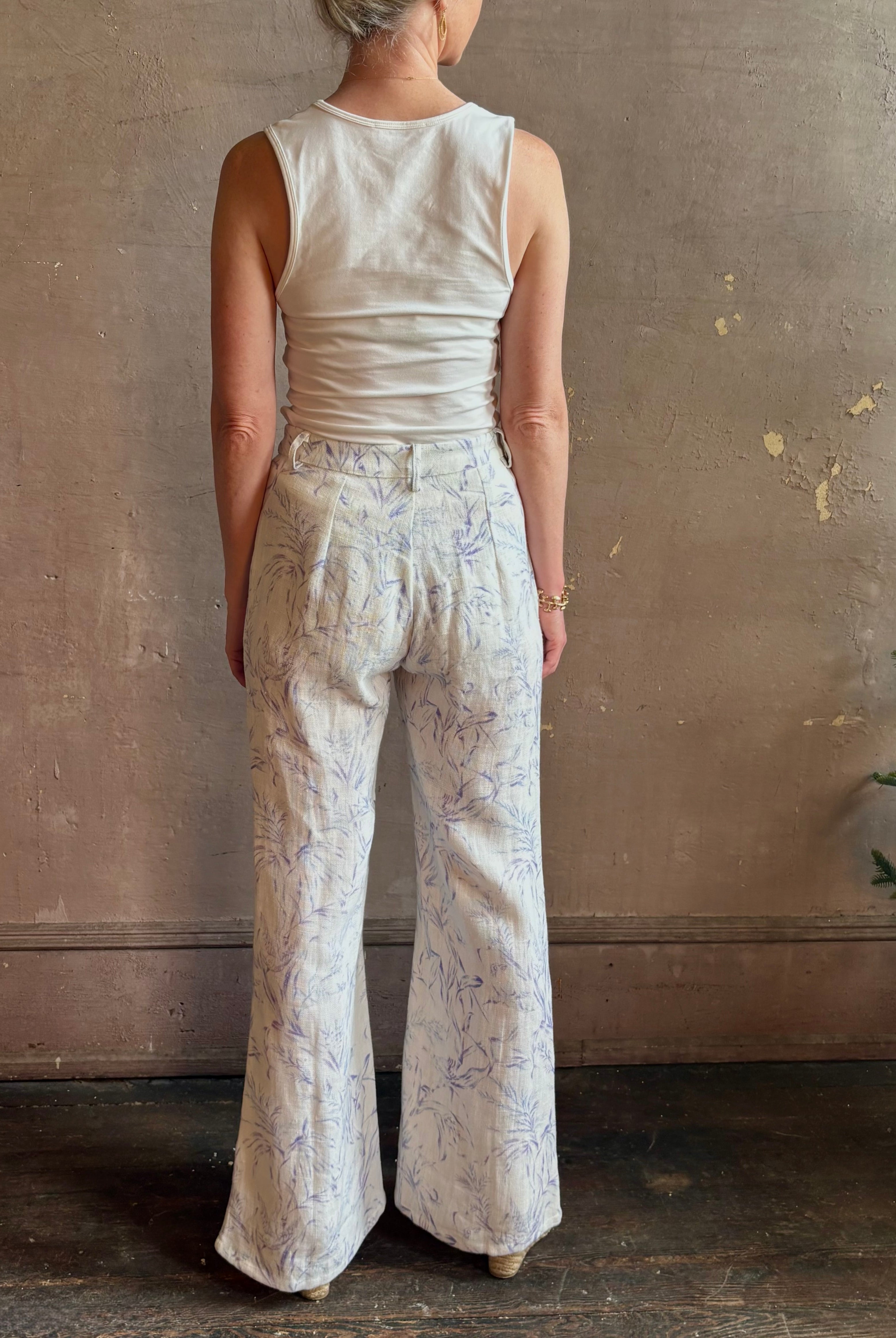 Woman wearing luxury designer Alix of Bohemia bunny toile summer weight linen trousers in white with blue print