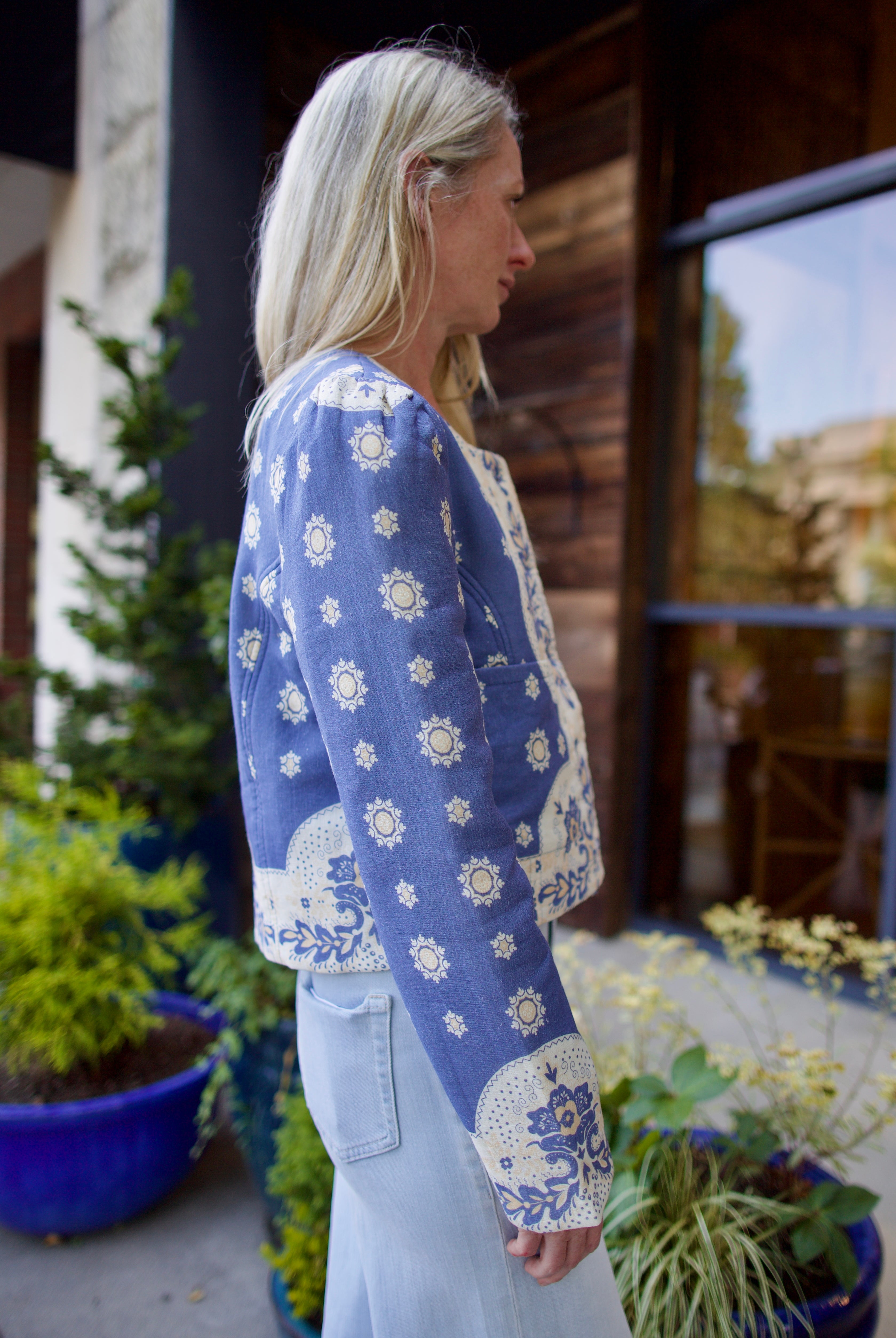 Model wearing luxury designer Alix of Bohemia Dorian jacket in blue marina bandana print with intricate details and feminine silhouette