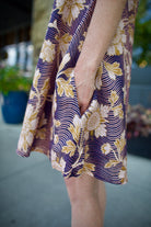 Model wearing a navy linen floral dress by high- end designer Alix of Bohemia Soleil Way Zinnia with v-neck and pockets