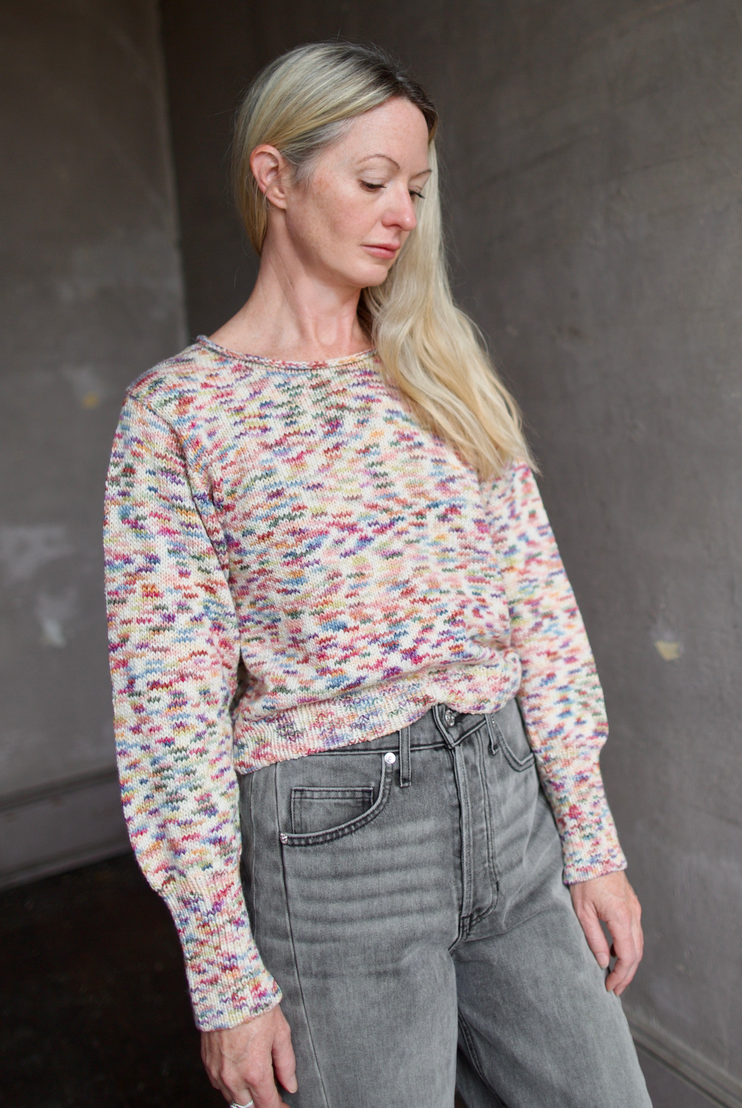 Model wearing an Alix of Bohemia colorful baby alpaca sweater and gray Veronica Beard barrel jeans