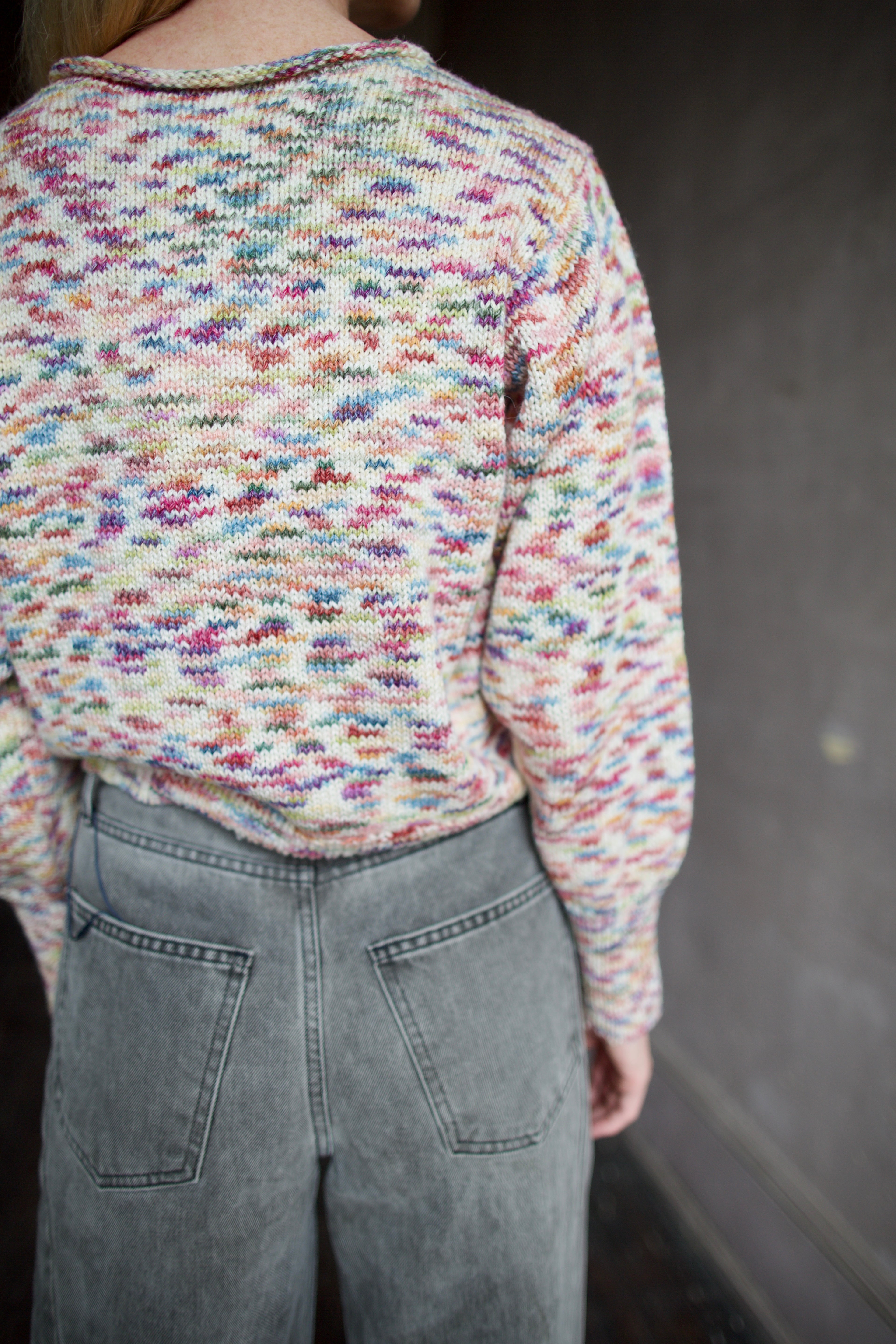 Model wearing an Alix of Bohemia colorful baby alpaca sweater and gray Veronica Beard barrel jeans