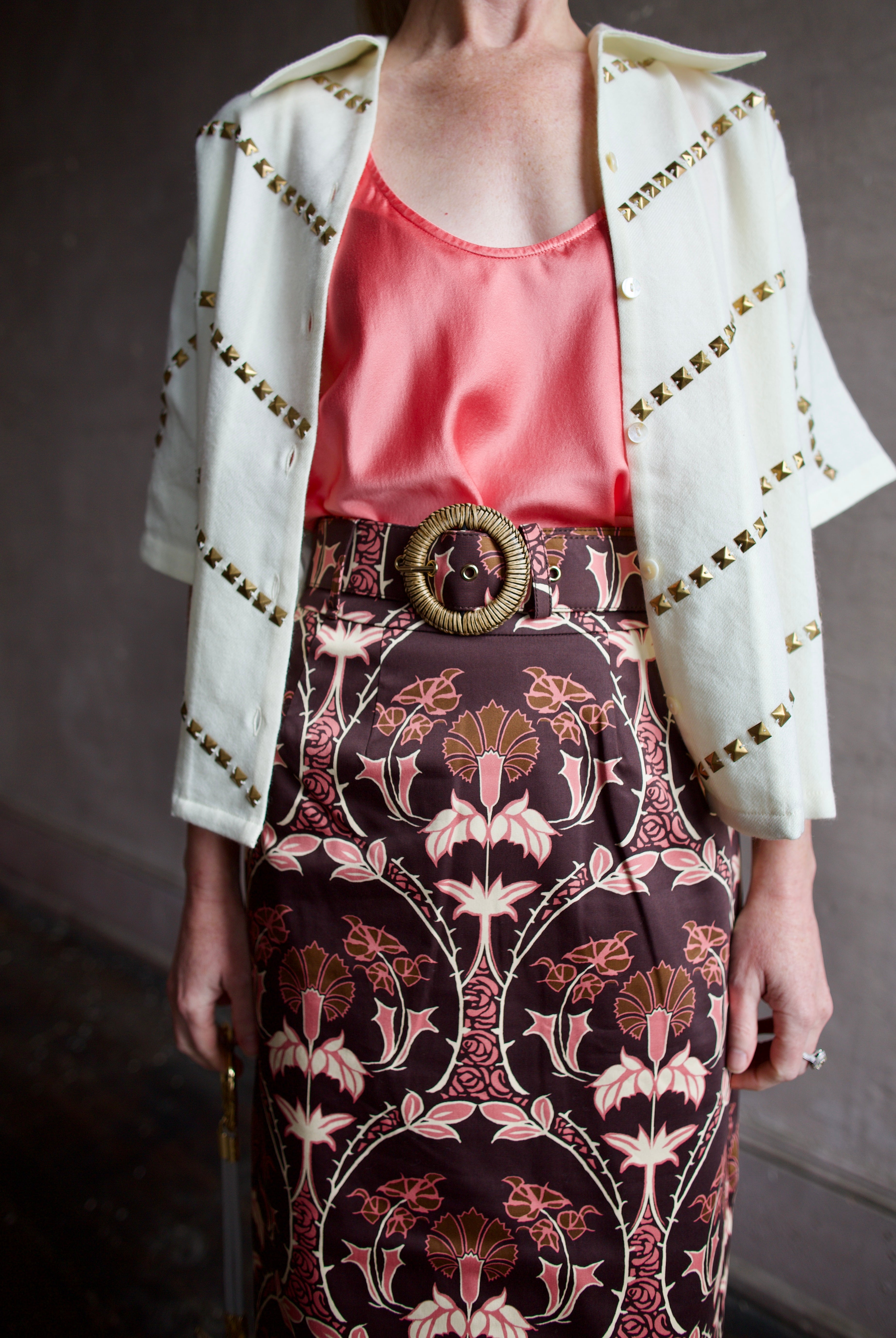 Close Up image of a woman wearing the Forte Forte Silk Tank, Alix of Bohemia Studded Top and Cara Cara Printed Skirt