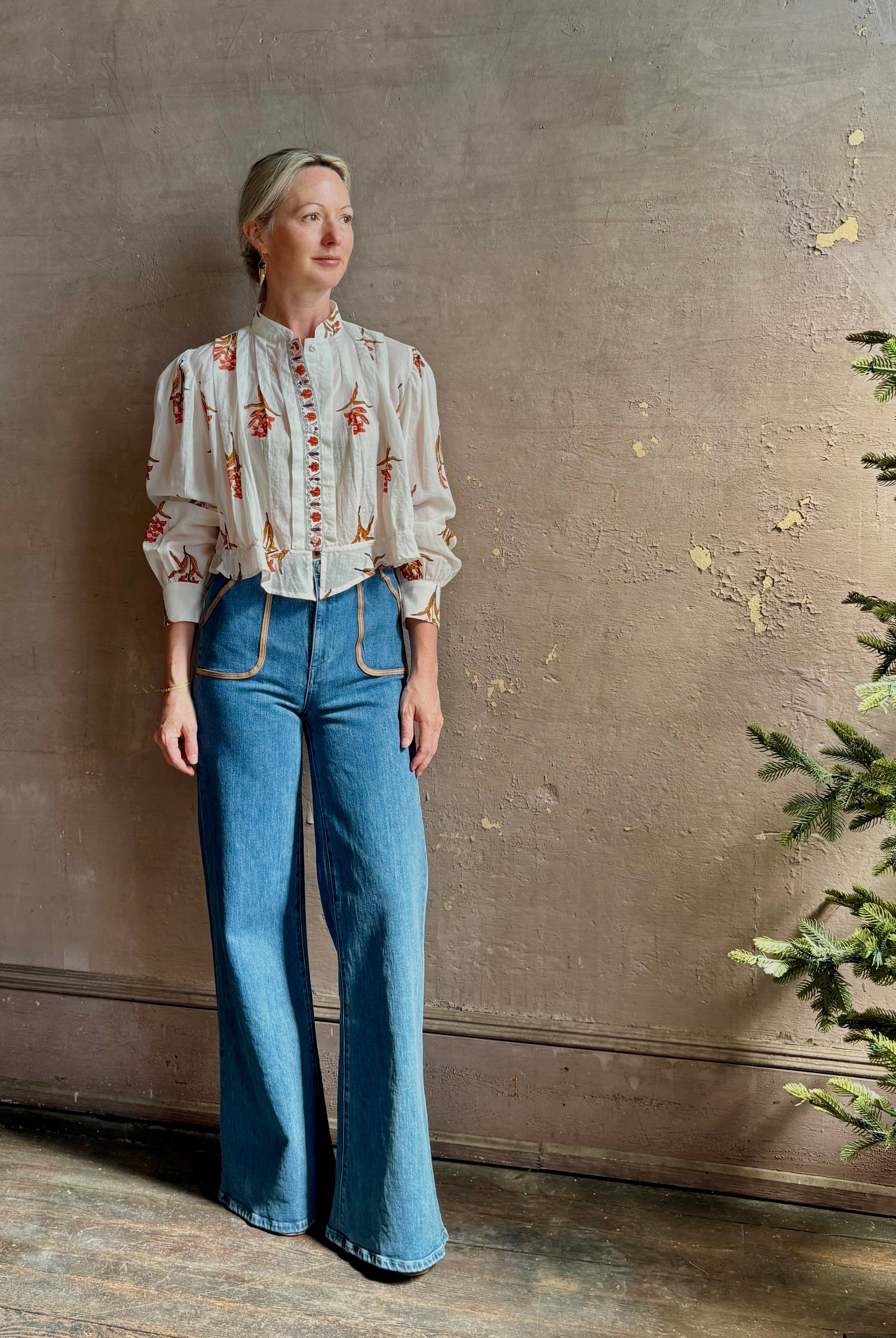 Mature woman wearing Alix of Bohemia Ryland Persimmon Flower Shirt with beautiful pin tucking and gathered waist detail at back, long sleeves, mandarin collar, and cropped top