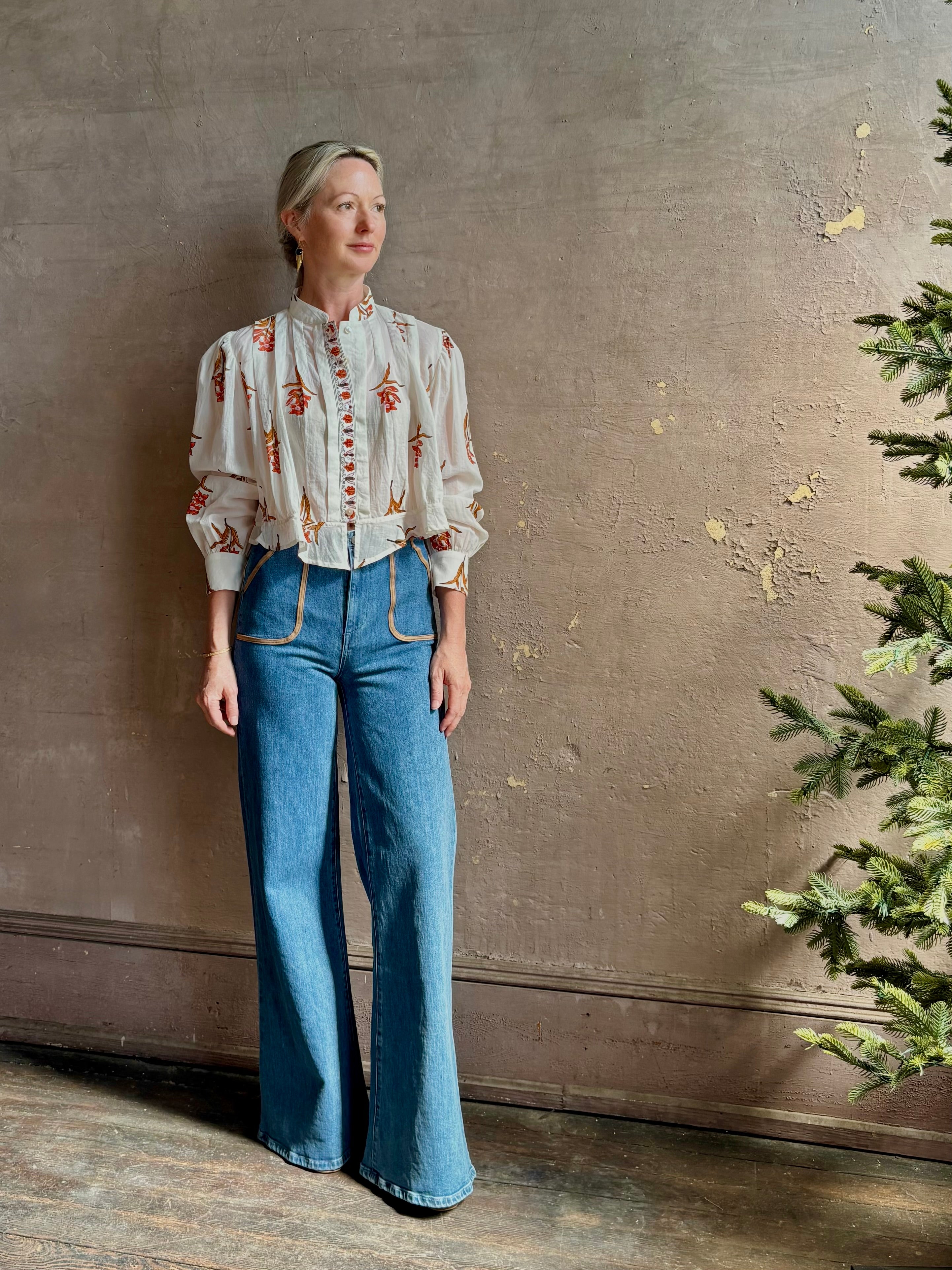 Mature woman wearing Alix of Bohemia Ryland Persimmon Flower Shirt with beautiful pin tucking and gathered waist detail at back, long sleeves, mandarin collar, and cropped top