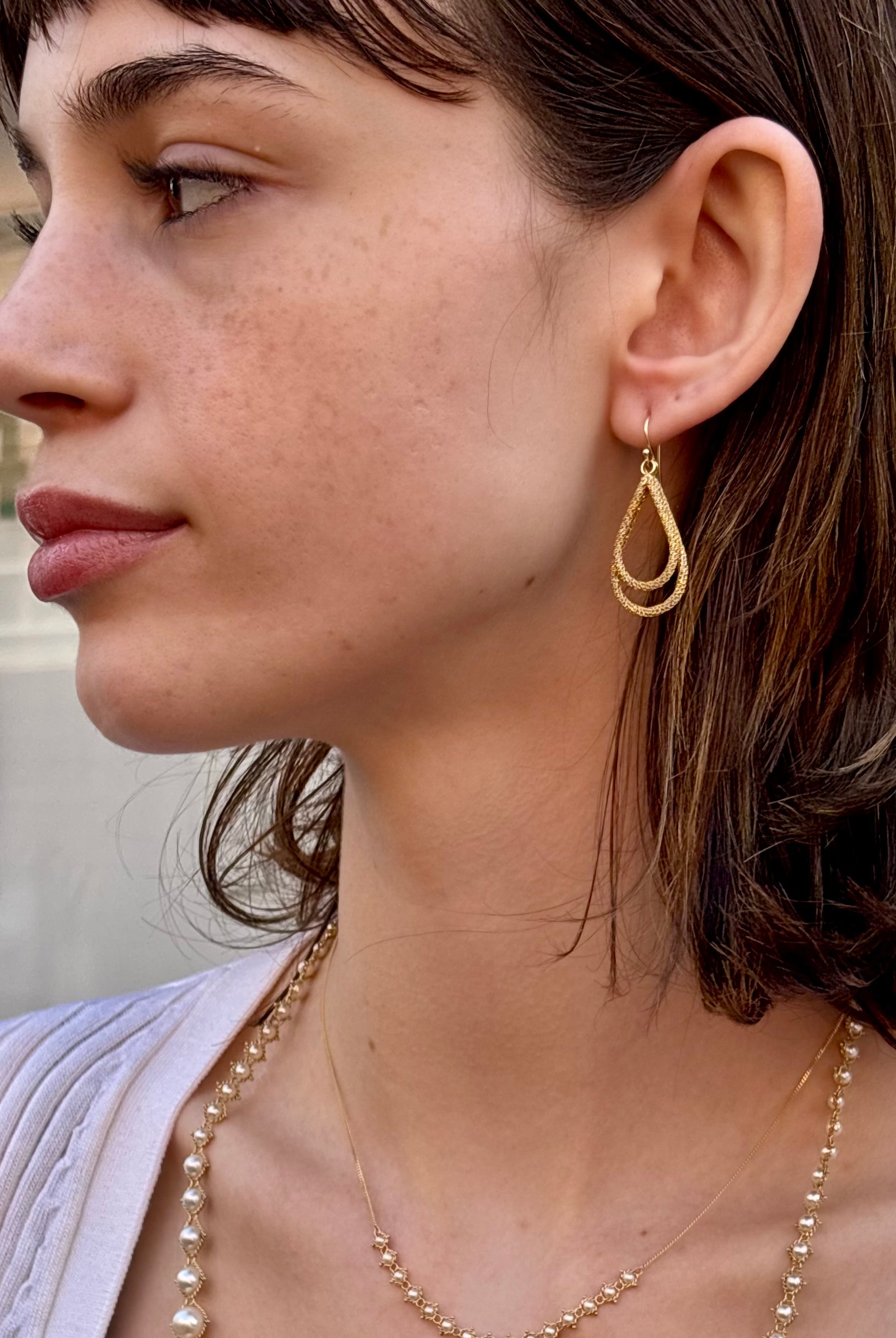 Woman wearing luxury designer Amali double Teardrop Stardust 18k yellow gold Earrings handmade in USA fine jewelry